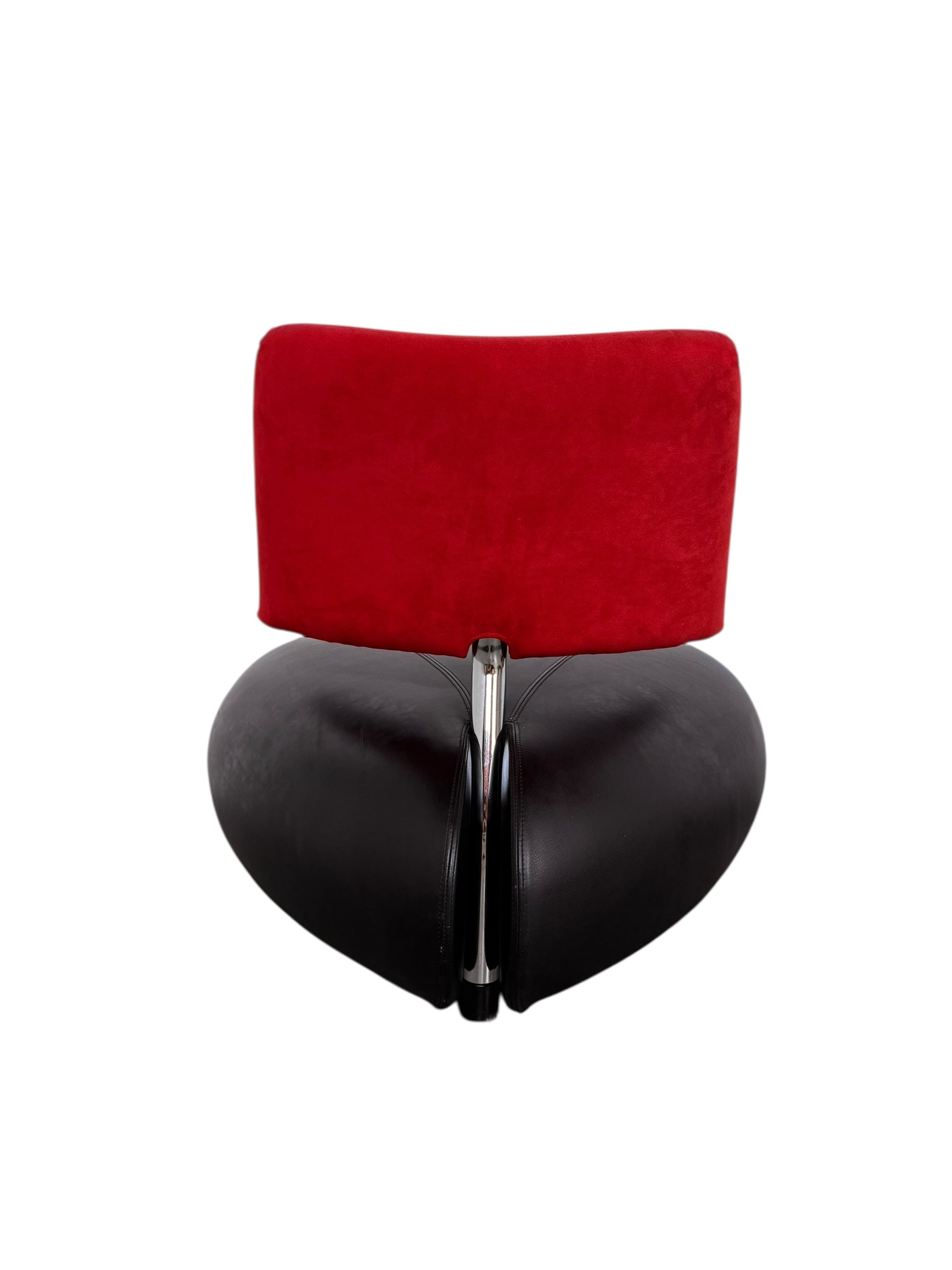 A Leolux Pallone armchair with a large, black, spherical leather seat and a smaller, red, curved leather backrest, supported by short metal legs.