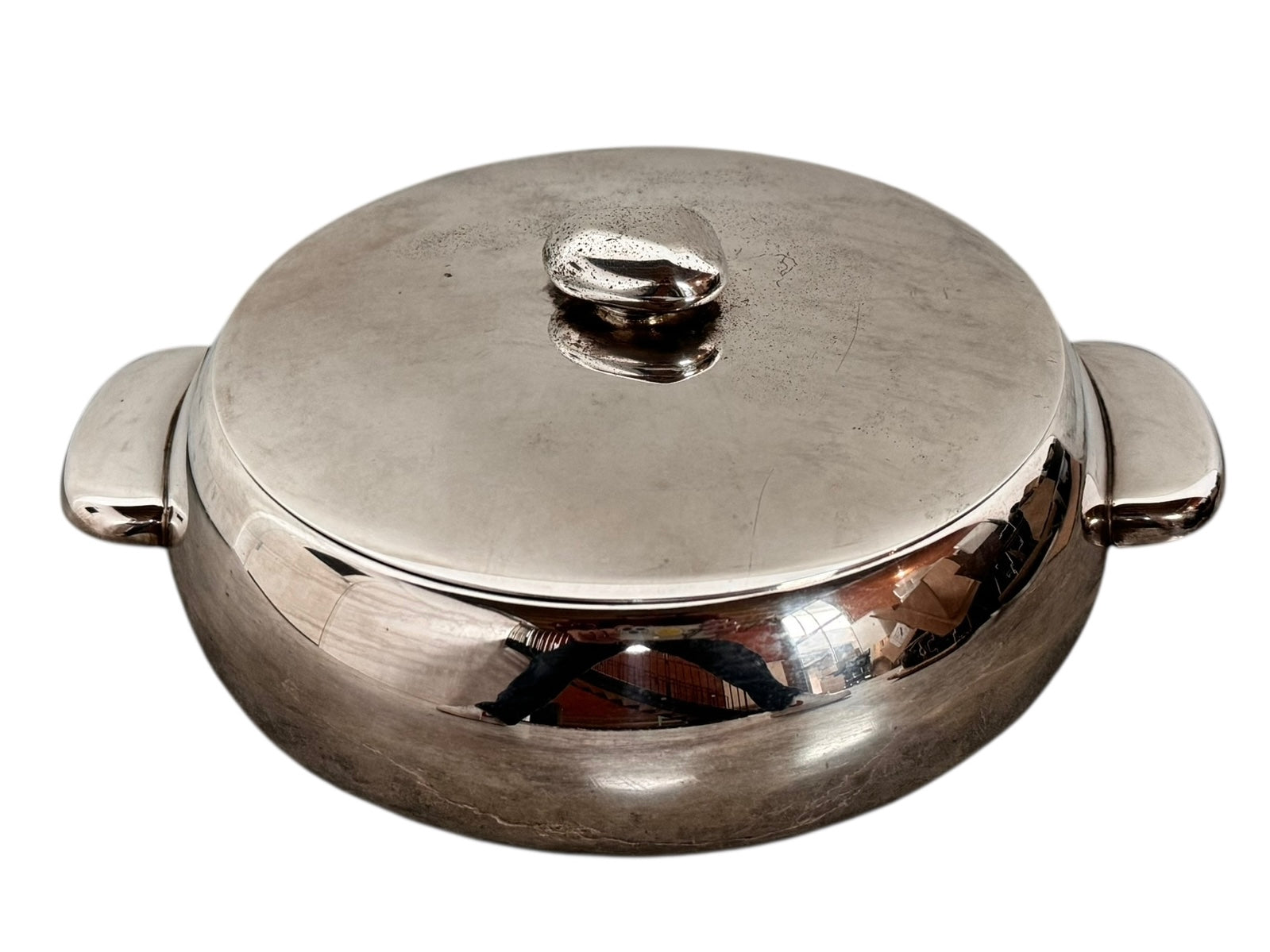 Round St. James silver-plated lidded serving dish from the 1980s, featuring a minimalist modernist design with geometric side handles and a sculptural, biomorphic finial, showing visible vintage wear and pitting on the metallic surface.