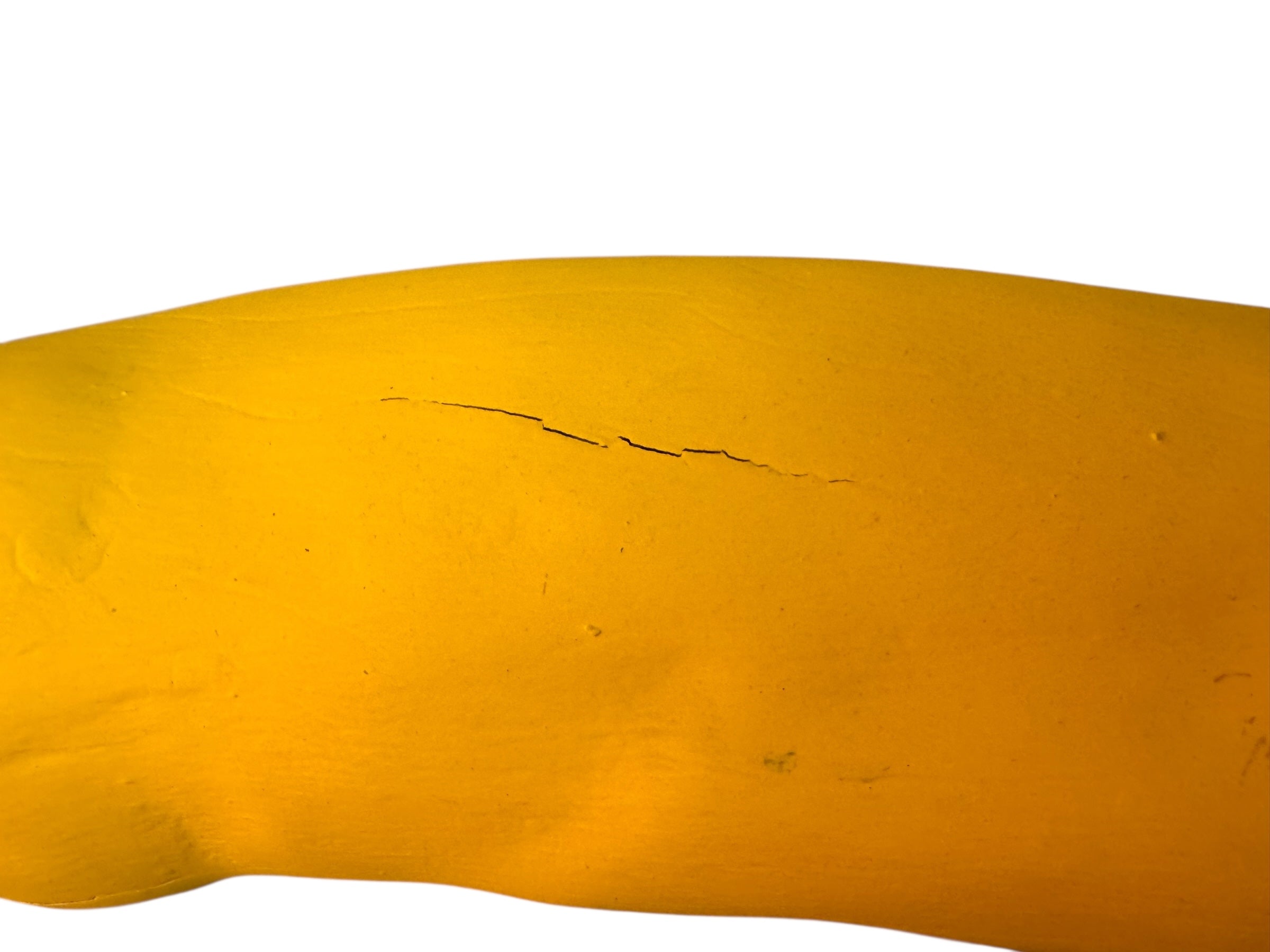 A bright yellow abstract sculpture depicting a calamari with a thick base and several thin, curving, branch-like extensions.