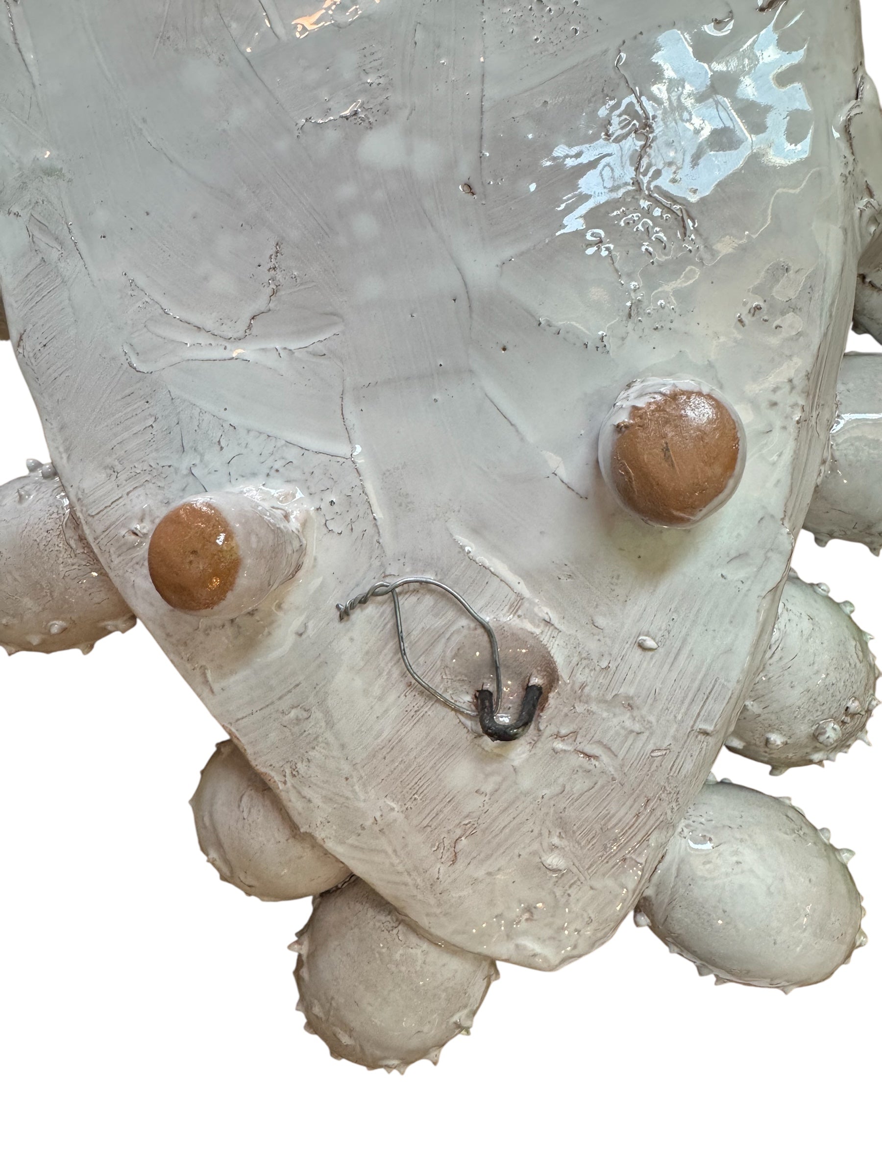 A white and green, glazed ceramic platter in the shape of a prickly pear cactus pad with attached prickly pear fruit. The surface has raised dots representing spines.