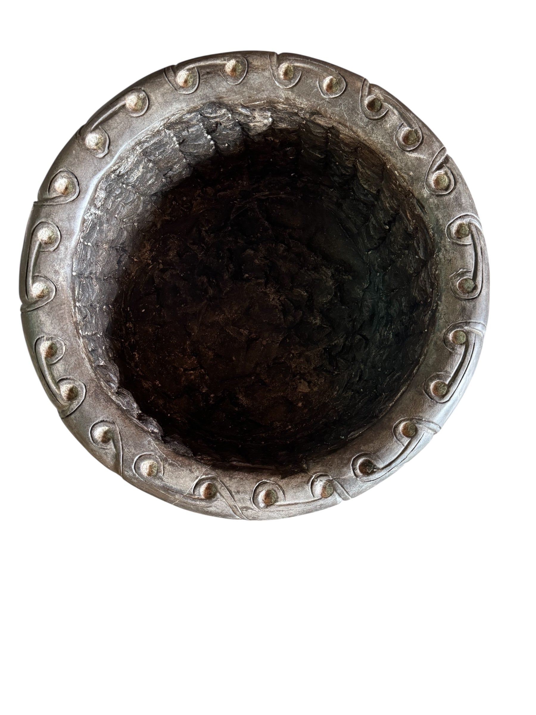 A heavy stone planter, featuring an intricate, hand-carved pattern resembling Celtic knot work.