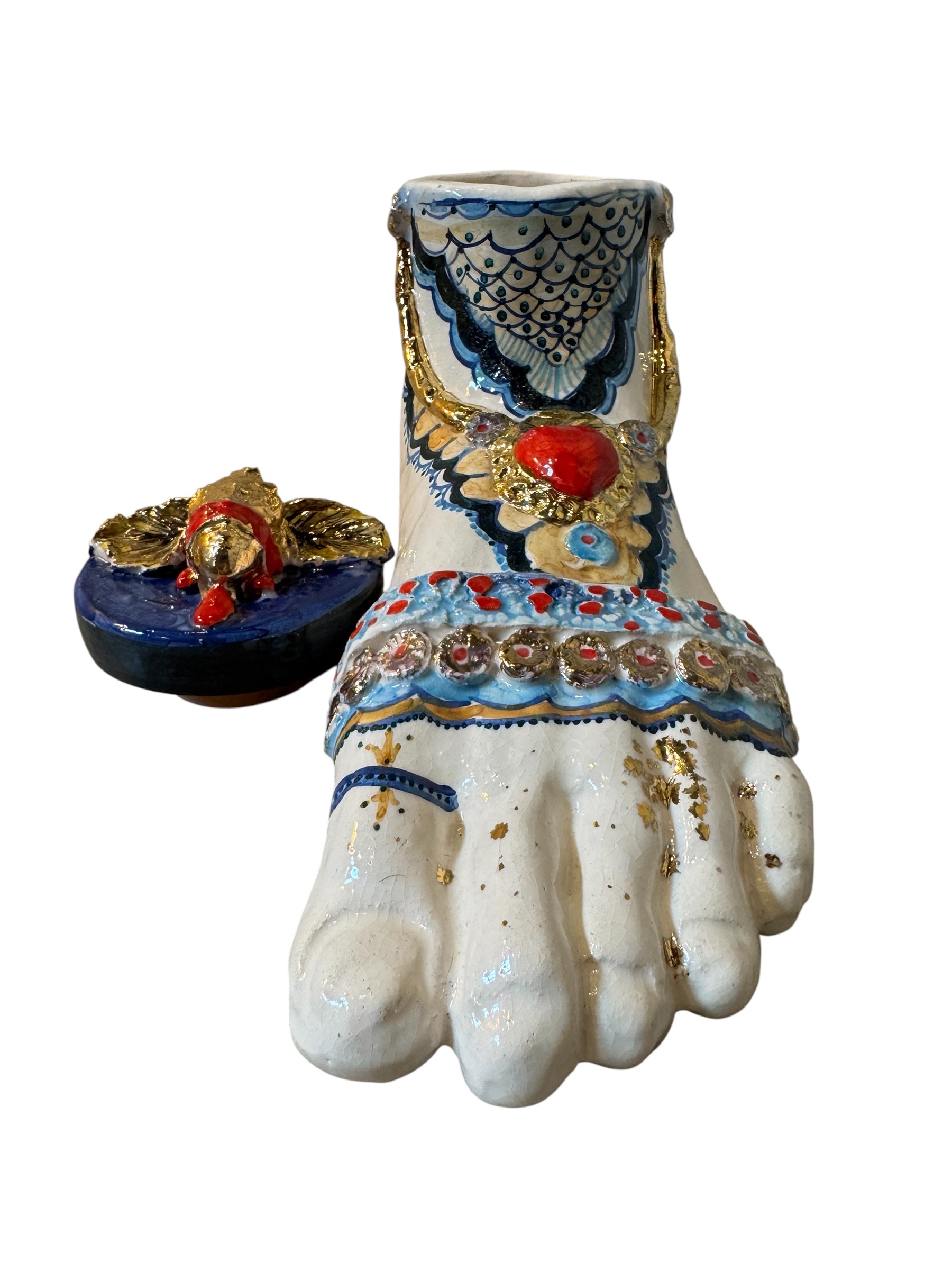 Ceramic foot sculpture by Domenico Pinto featuring hand-painted details, gold accents, a sacred heart, and an angel figure with a blindfold