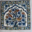 floral and bird pattern on a white background. Vibrant cross-stitched pillows from India with various artistic designs, sourced in Aix-en-Provence.