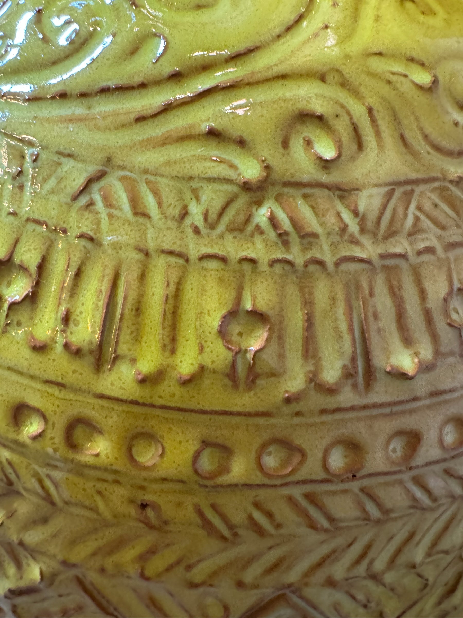 Yellow ceramic sculpture titled 'The Ram Oracle' by Enza Fasano, featuring a round body with intricate, hand-incised patterns and long, stylized ram-like horns