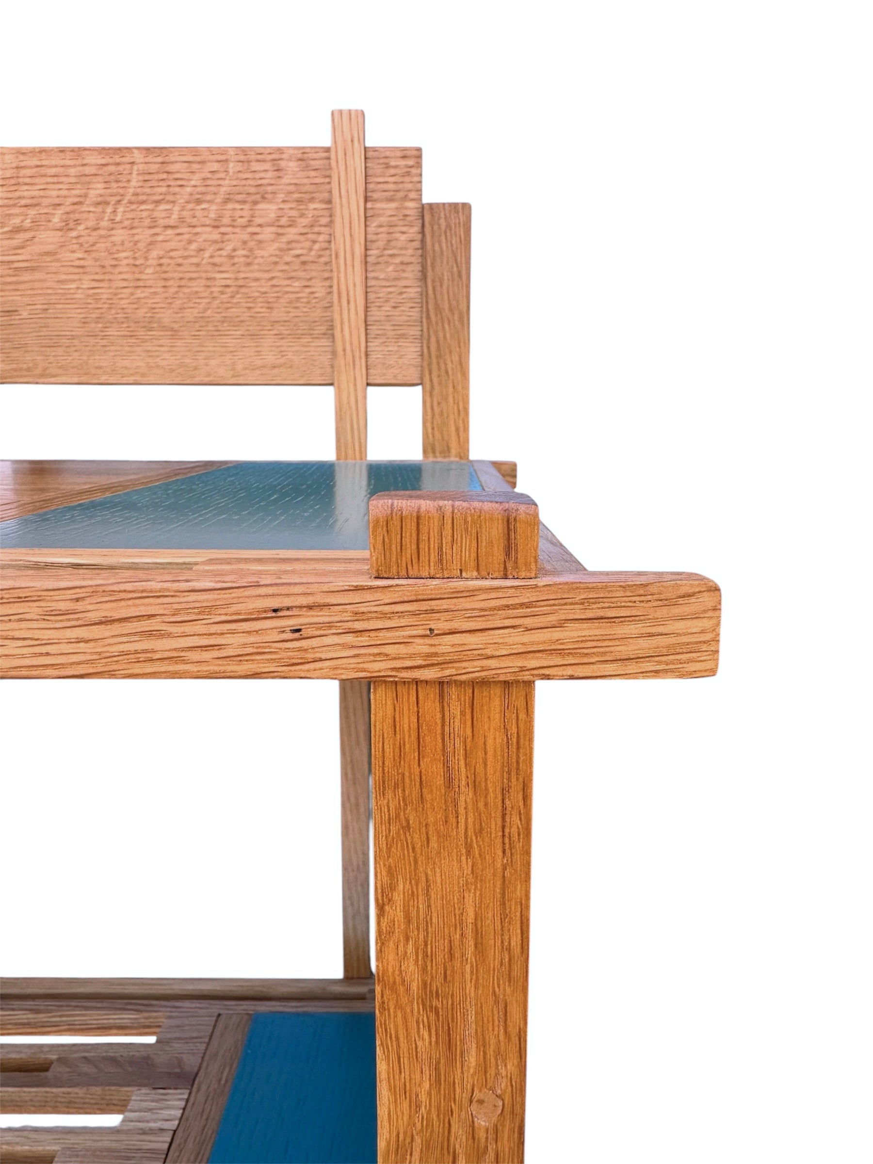 A three-tiered wooden shelving unit featuring a mix of light oak and teal-colored panels. The piece has an open, structural design with visible joinery, vertical supports that extend past the top shelf, and a horizontal backrest at the top. The middle and bottom shelves feature slatted wood center sections flanked by solid teal panels, while the top surface is primarily solid wood with teal accents at the edges.