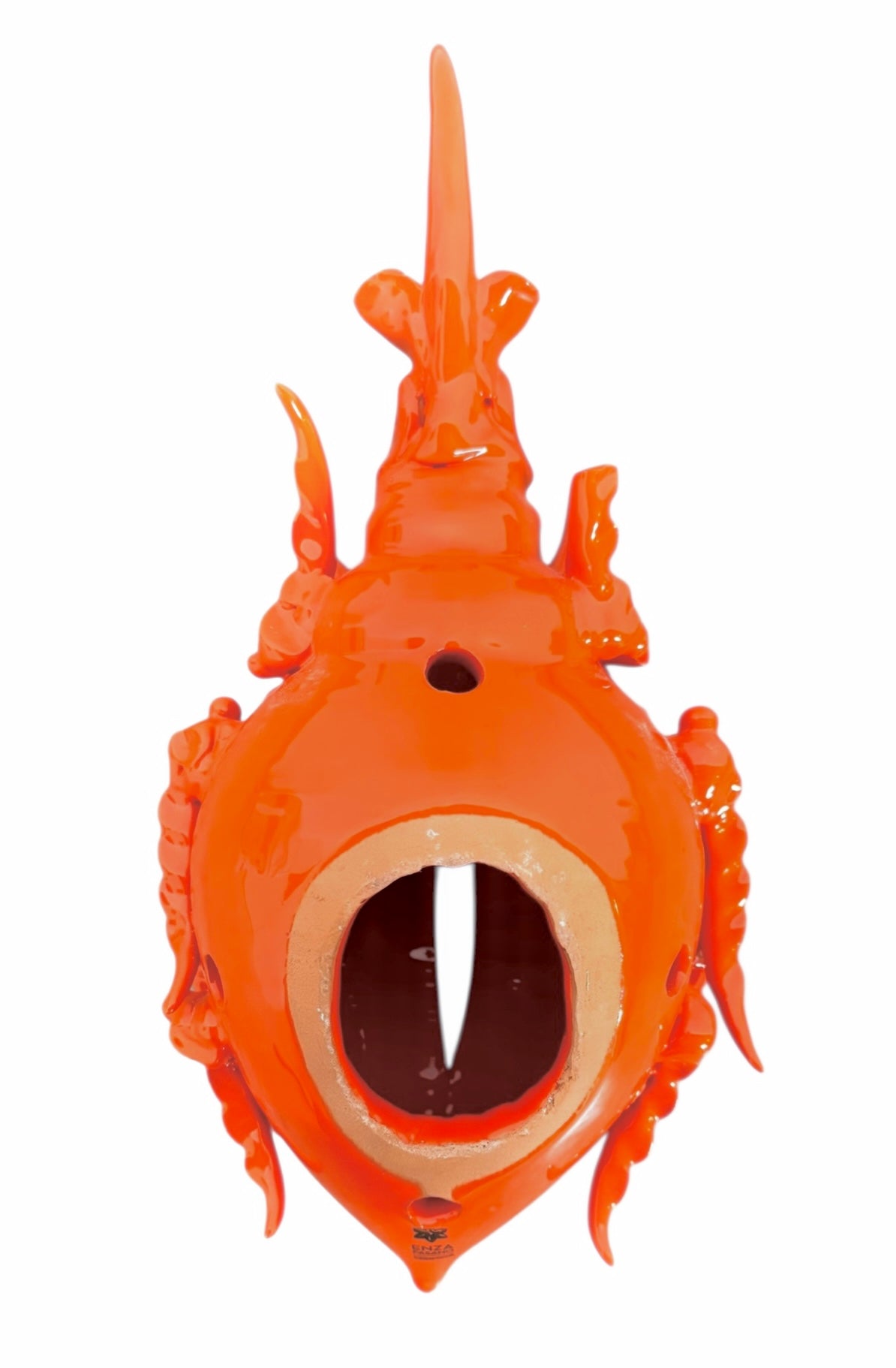 A glossy, vibrant orange ceramic sculpture of a rhinoceros beetle by Enza Fasano. The piece features a highly polished, reflective glaze and stylized, fluid anatomical details. Its prominent dual horns curve forward, and the body is textured with layered, wing-like plates, set against a plain white background.