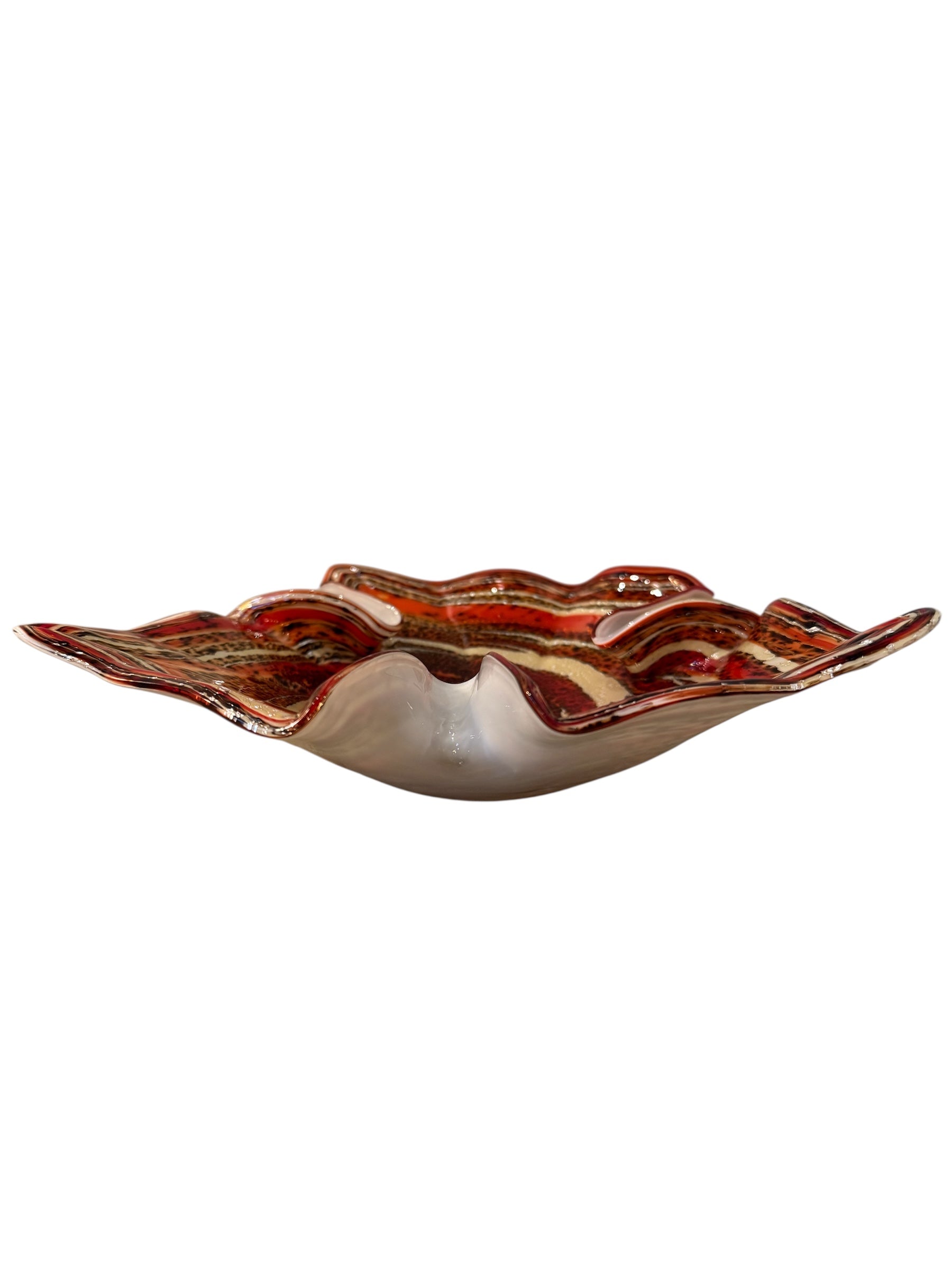 A Murano art glass bowl with a freeform shape, featuring layered swirls of brown, orange, and cream, accented with gold flecks. The bowl has a translucent white base.