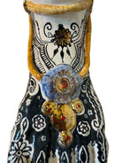 Handcrafted ceramic sculpture in the shape of a foot, decorated with intricate black and white patterns, 24KT gold accents, and topped with a blue lid featuring a gilt fish and head emerging from stylized waves.