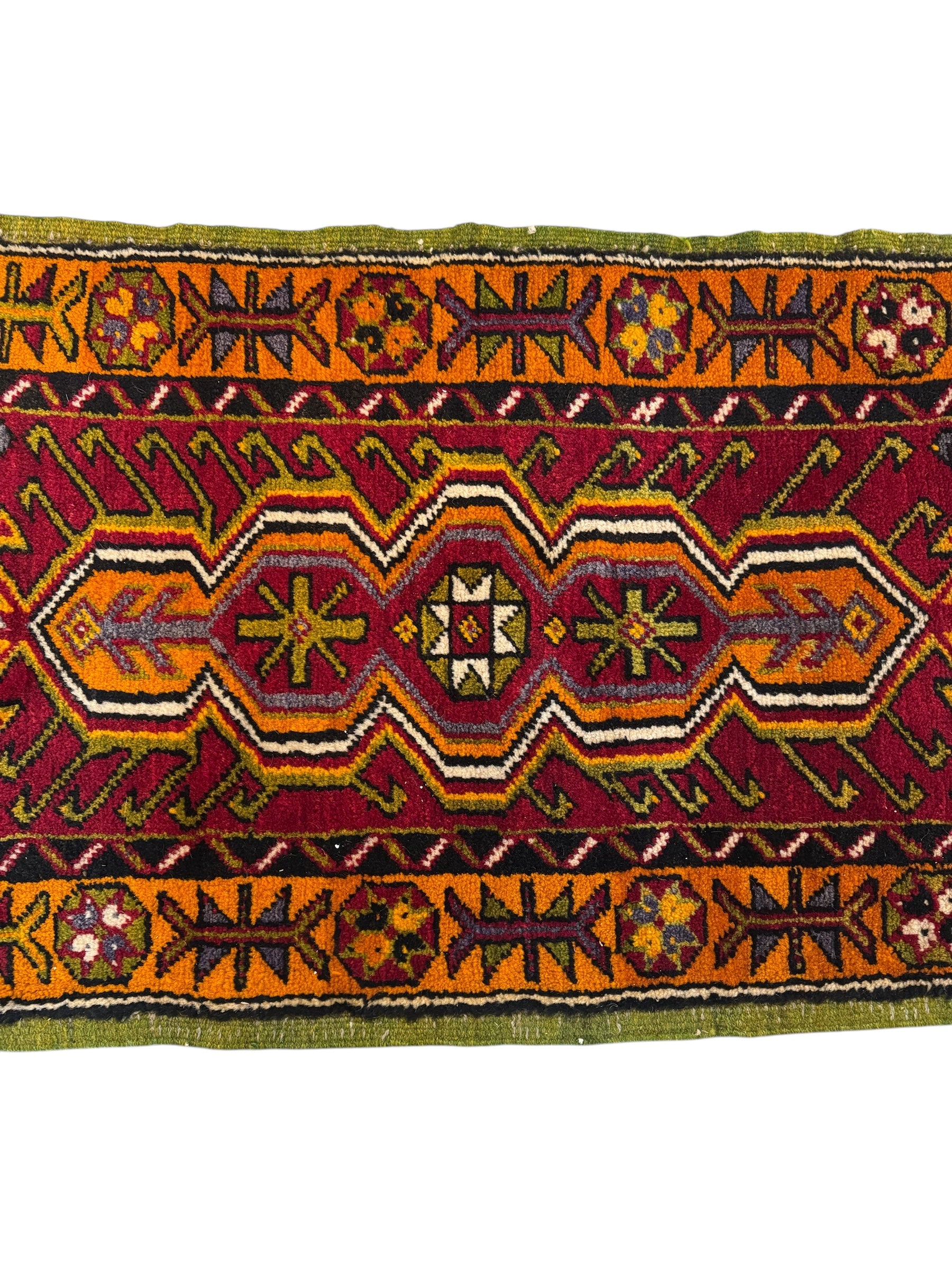 Anatolian Yastik rug with red, gold, green and gray geometric patterns and fringe.