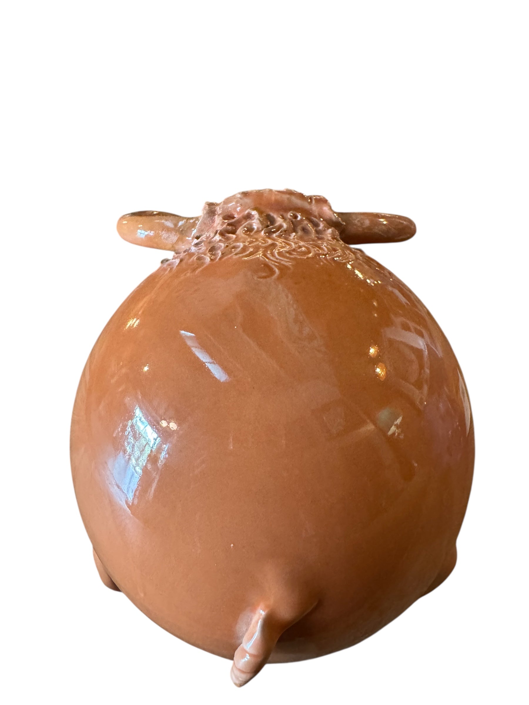 Terracotta colored ceramic Highland cow sculpture with a shaggy coat and curved horns