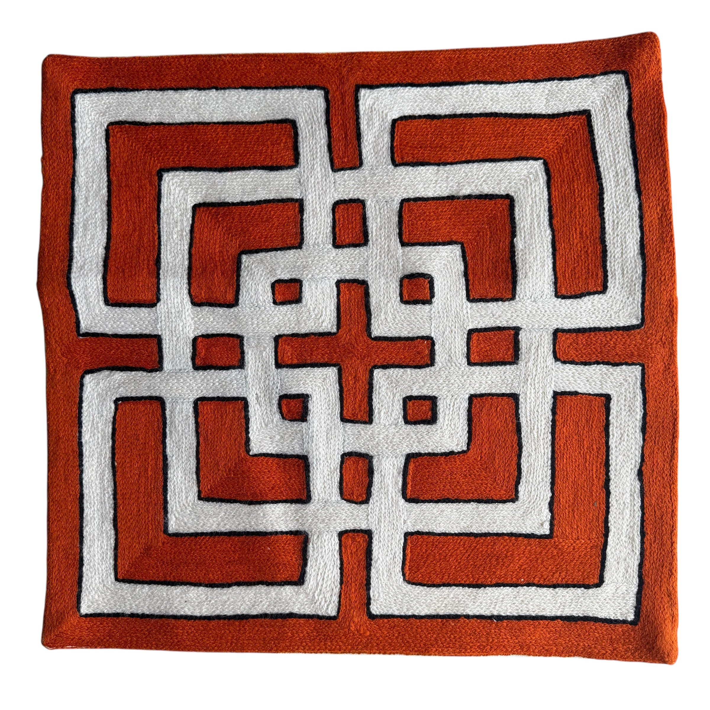 Decorative throw pillow with geometric pattern . Orange and white. Vibrant cross-stitched pillows from India with various artistic designs, sourced in Aix-en-Provence.