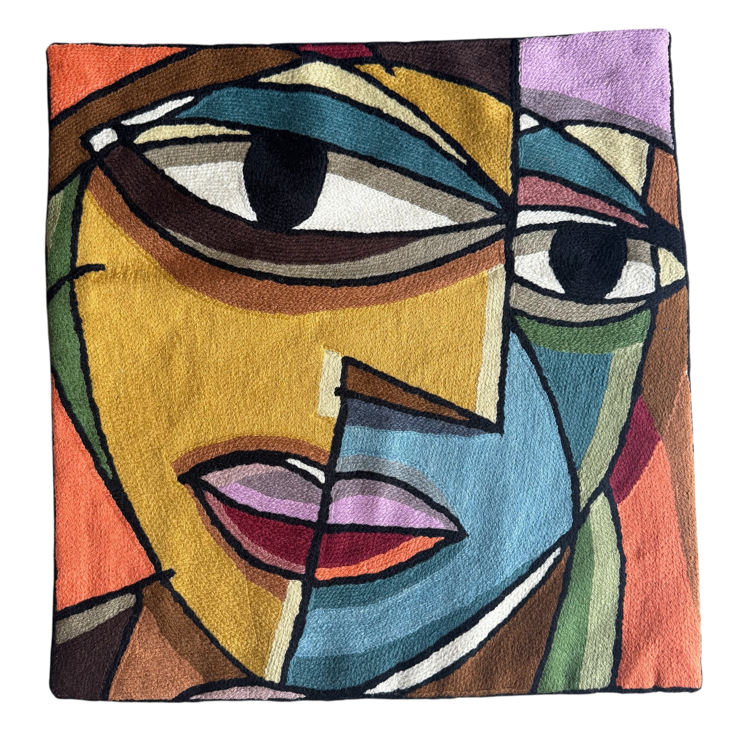 Face motif. Vibrant cross-stitched pillows from India with various artistic designs, sourced in Aix-en-Provence.
Exquisite Cross-Stitched Pillows: A Global Fusion of Color and Craft