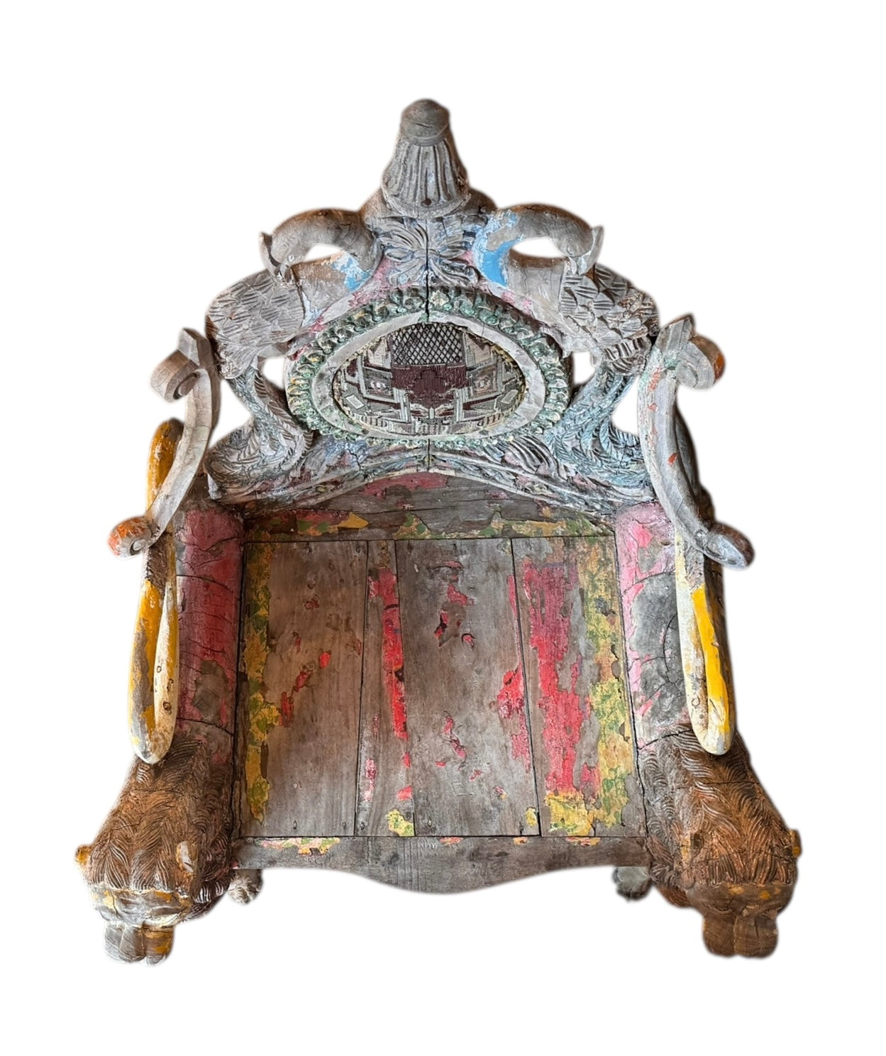A pair of antique, heavily carved Anglo-Indian style throne chairs featuring lion figures as legs and arm supports, and peacock motifs on the backrests. The chairs have a distressed, multi-colored painted finish.