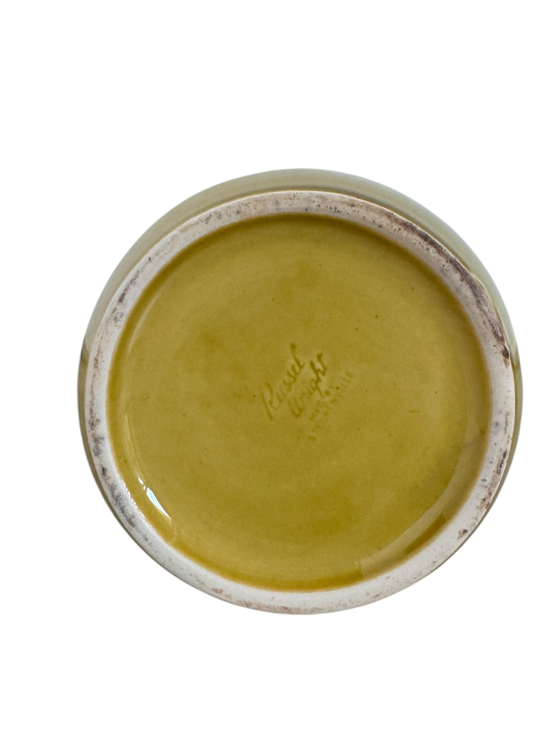 A chartreuse (yellow-green) ceramic pitcher designed by Russel Wright, featuring a teardrop shape, an elongated spout, and a curved handle