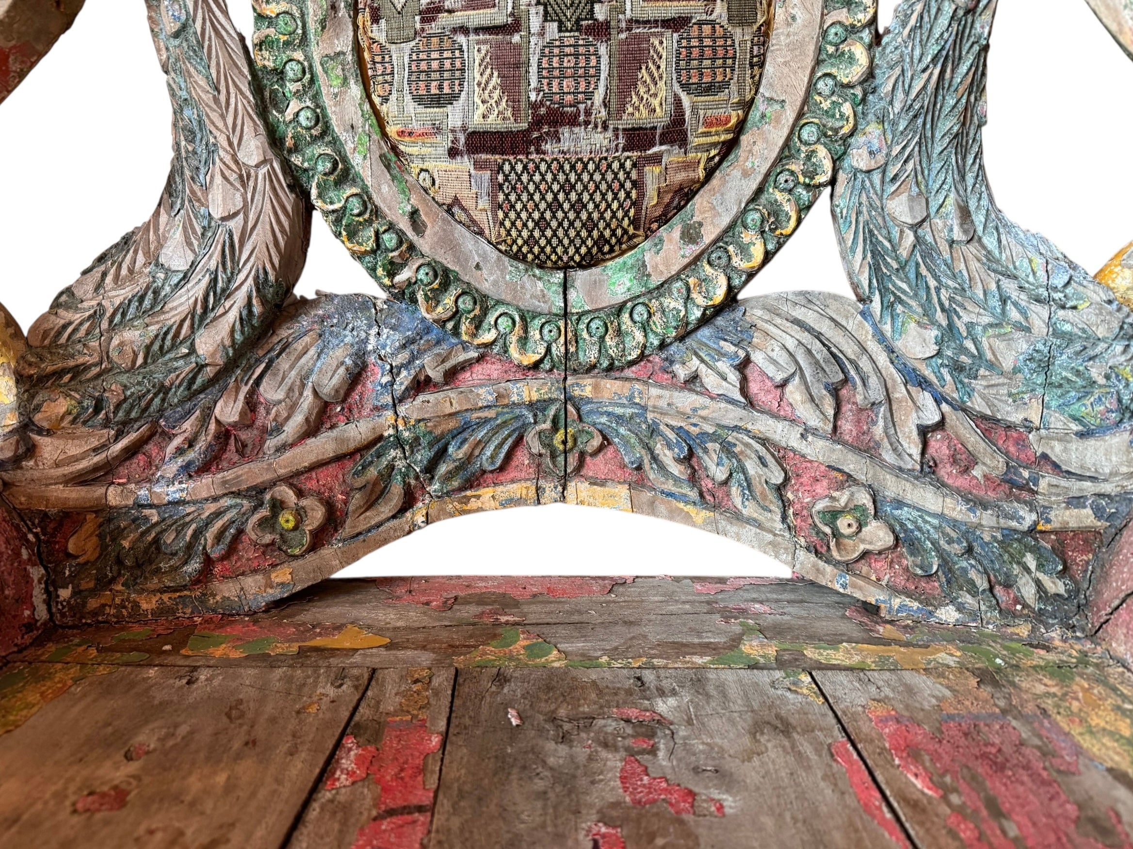 A pair of antique, heavily carved Anglo-Indian style throne chairs featuring lion figures as legs and arm supports, and peacock motifs on the backrests. The chairs have a distressed, multi-colored painted finish.
