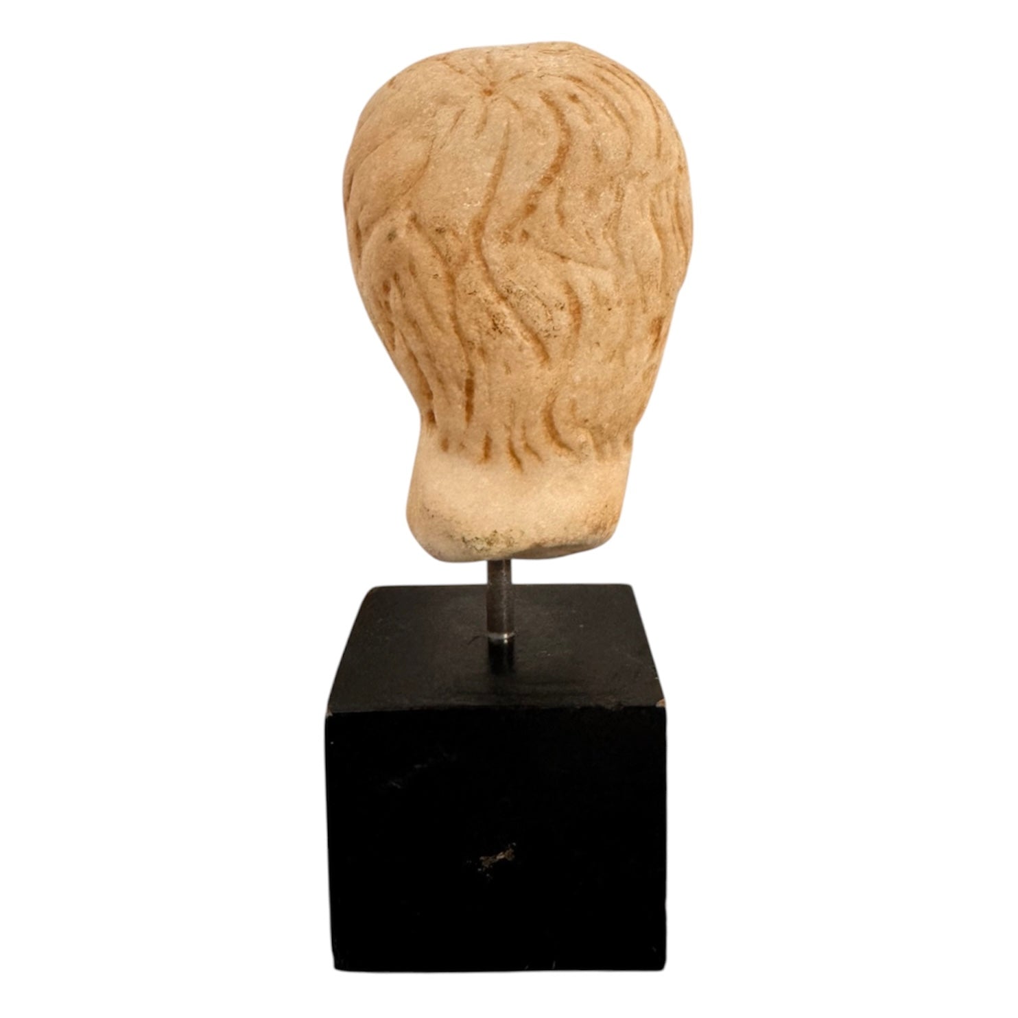 An ancient marble sculpted head of a young man, presented on a modern black presentation stand. The sculpture is rendered in a three-quarter view, angled slightly to the right, showing a classical profile characterized by a strong nose, softly contoured cheekbones, and slightly parted lips that convey a quiet, contemplative expression. The hair is carved in short, stylized strands that frame the forehead and ears, characteristic of ancient Roman or Greek portraiture styles.