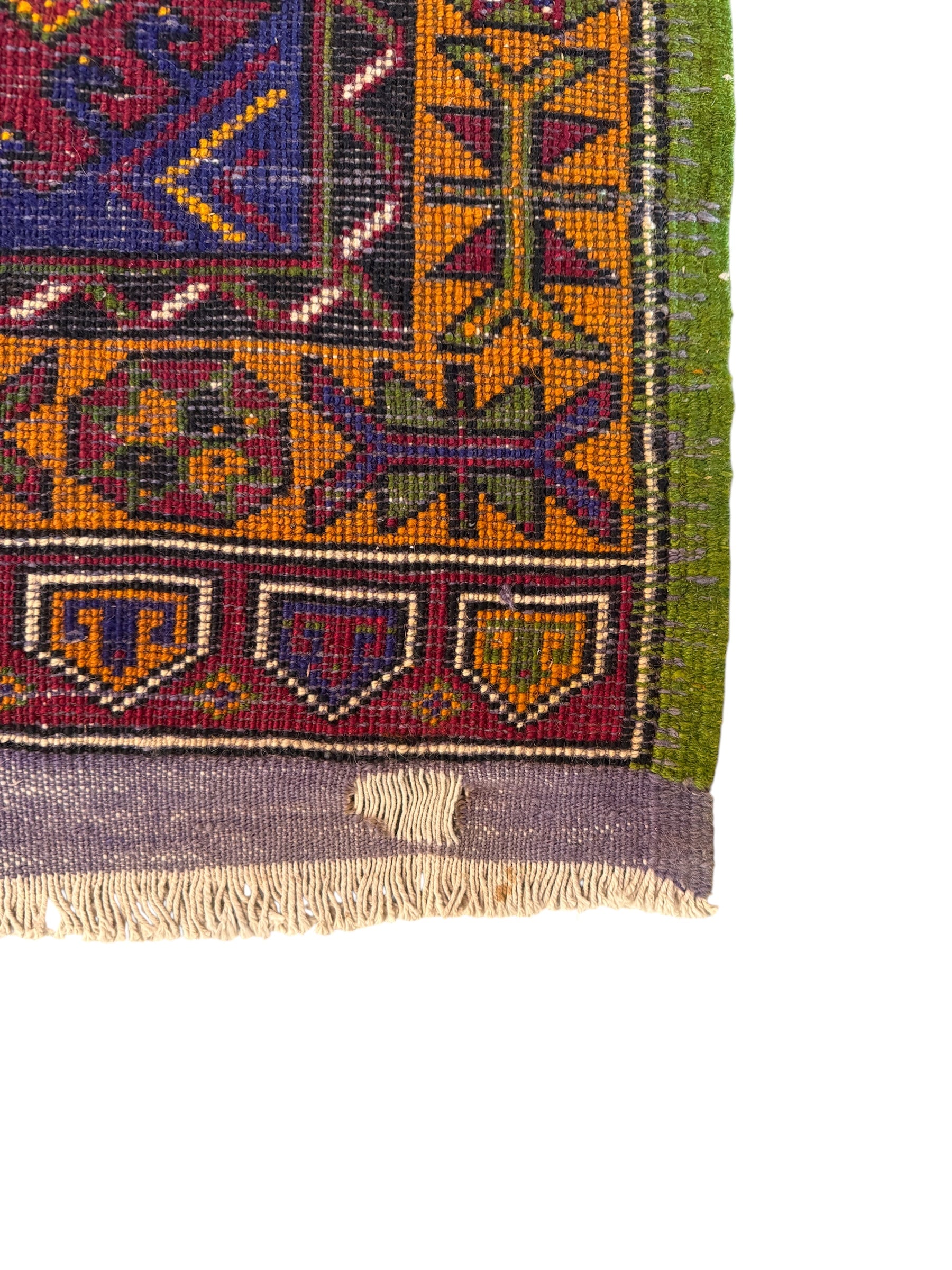 Anatolian Yastik rug with red, gold, green and gray geometric patterns and fringe.