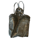 A sculpture by Marilyn Lanfear made of lead with embellishments, featuring  a floral or star-shaped detail on the top, with visible signs of aging or markings. 
Genie Sonia with Rykiel Label