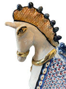 Ceramic horse by Domenico Pinto, featuring a white glazed body, geometric quilting on the saddle, gold accents, and 24Kt gold detailing. The horse stands on four legs and is placed on a white base.