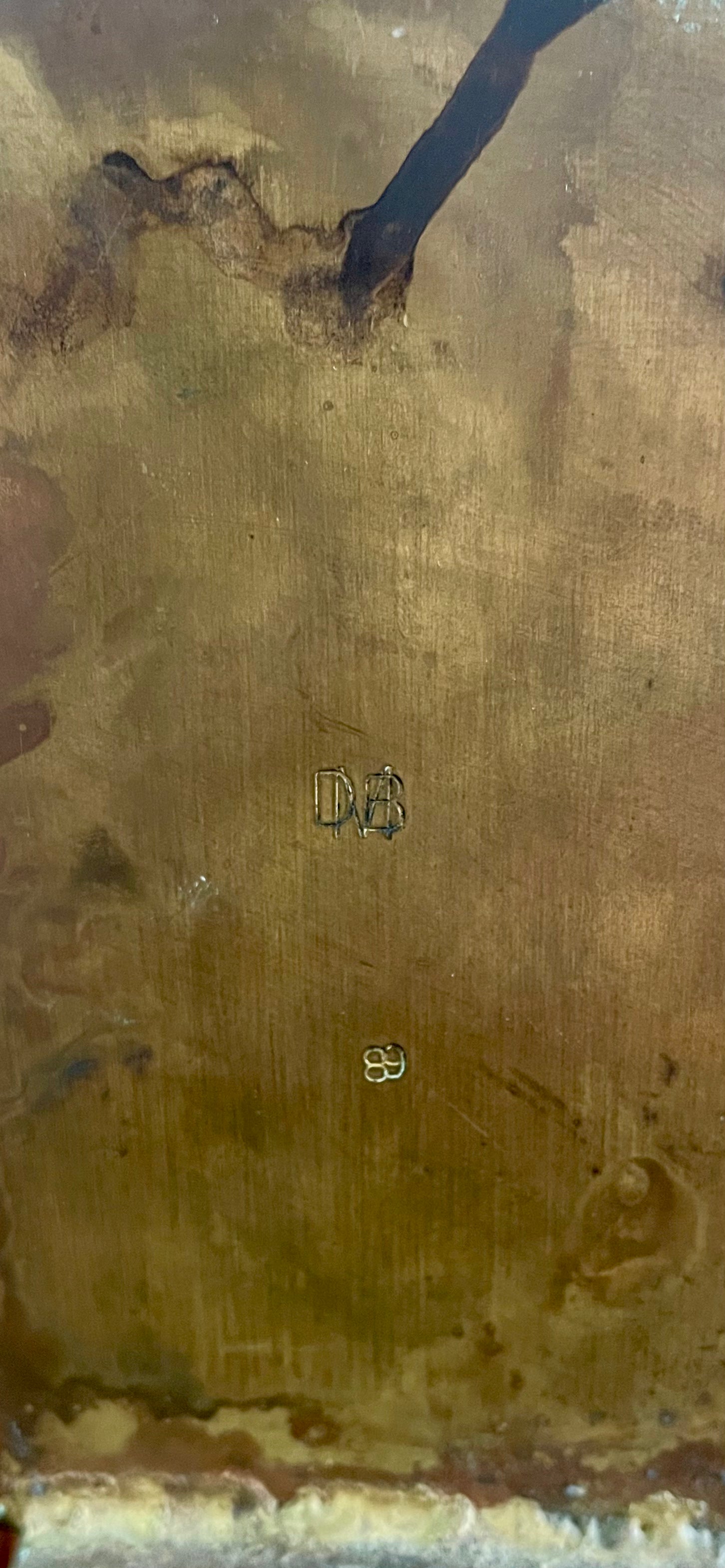 Close-up of two David Marshall Brutalist bookends. The bookends feature contrasting silver and bronze metal panels, separated by raised textured bronze seams. The bookends have a rough, geometric design.