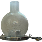 An Italian mid-century Murano glass table lamp with a chrome metal base and a textured glass shade featuring numerous suspended bubbles.