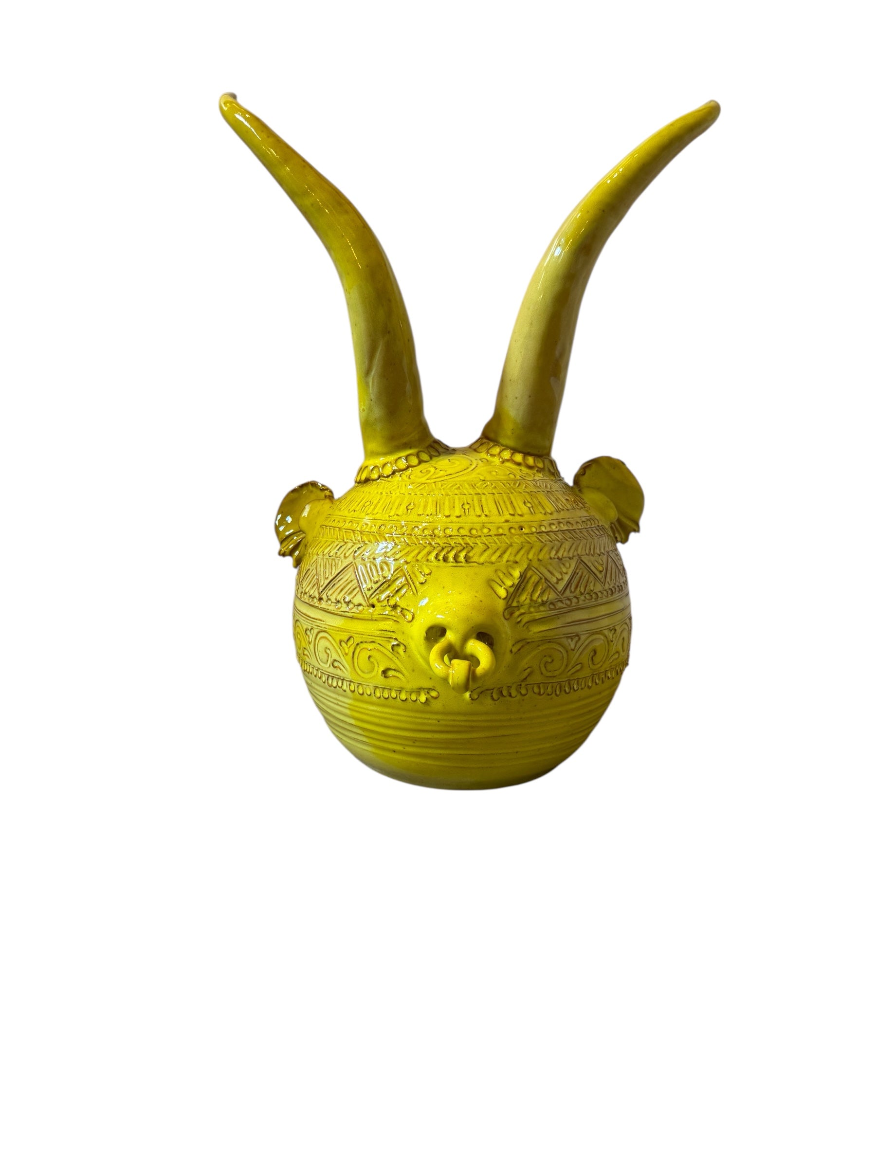 Yellow ceramic sculpture titled 'The Ram Oracle' by Enza Fasano, featuring a round body with intricate, hand-incised patterns and long, stylized ram-like horns.
L'Oracolo Ariete by Enza Fasano Ceramiche