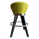 A green mid-century modern counter stool with dark wood legs, a chrome footrest, and recently reupholstered seat fabric.