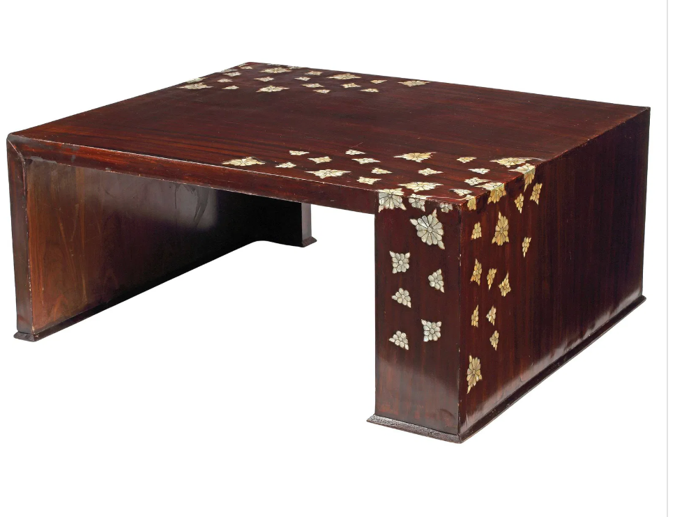 A rectangular, dark wood coffee table featuring scattered floral mother-of-pearl/shell inlays on its top surface and one side.