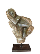 Figural sculpture in the Shona style, Zimbabwe. Two abstracted figures are intertwined, carved from greenish-brown soapstone. Sculpture rests on a dark iron stand.