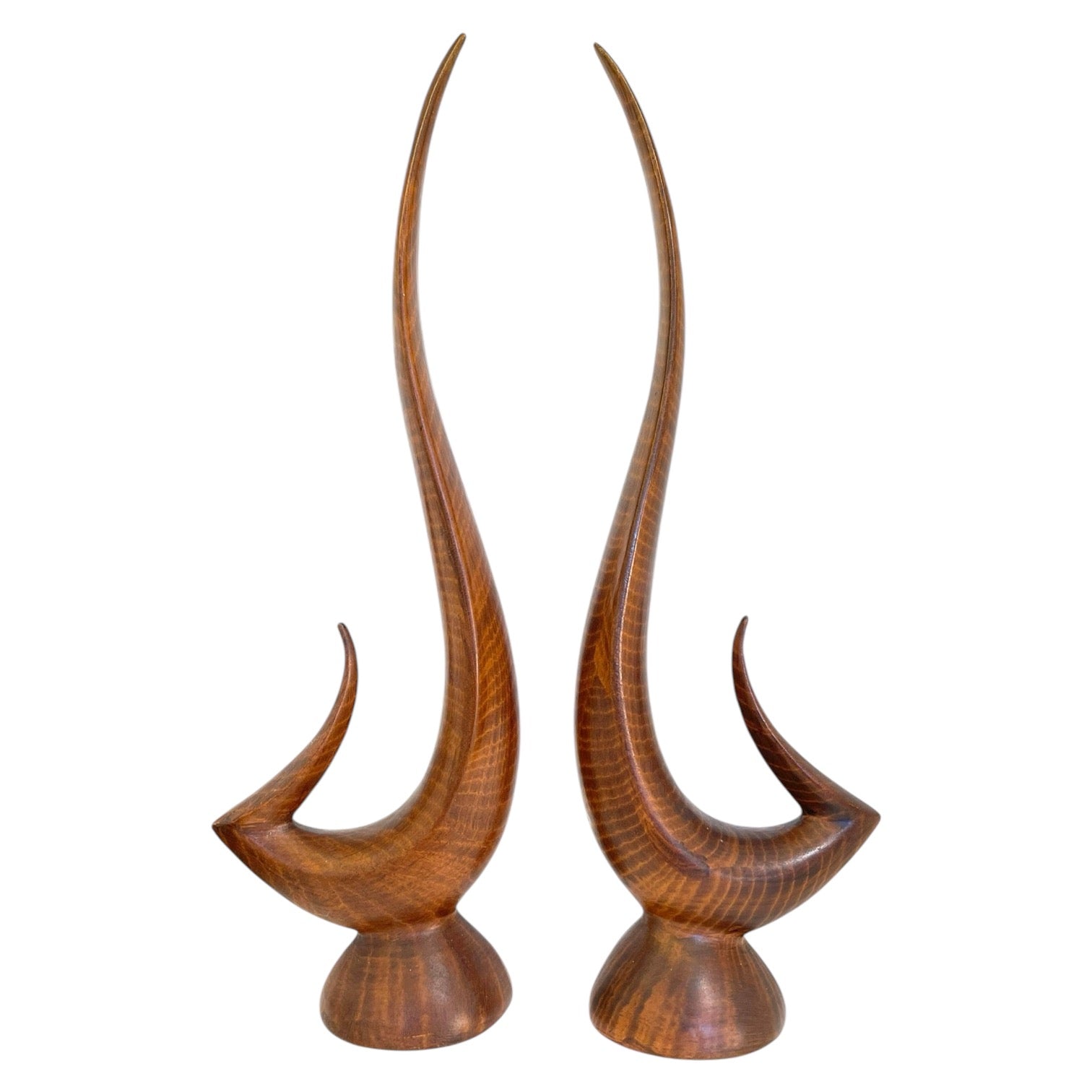 A pair of ceramic sculptures shaped like swans with a faux bois (imitation wood) finish.