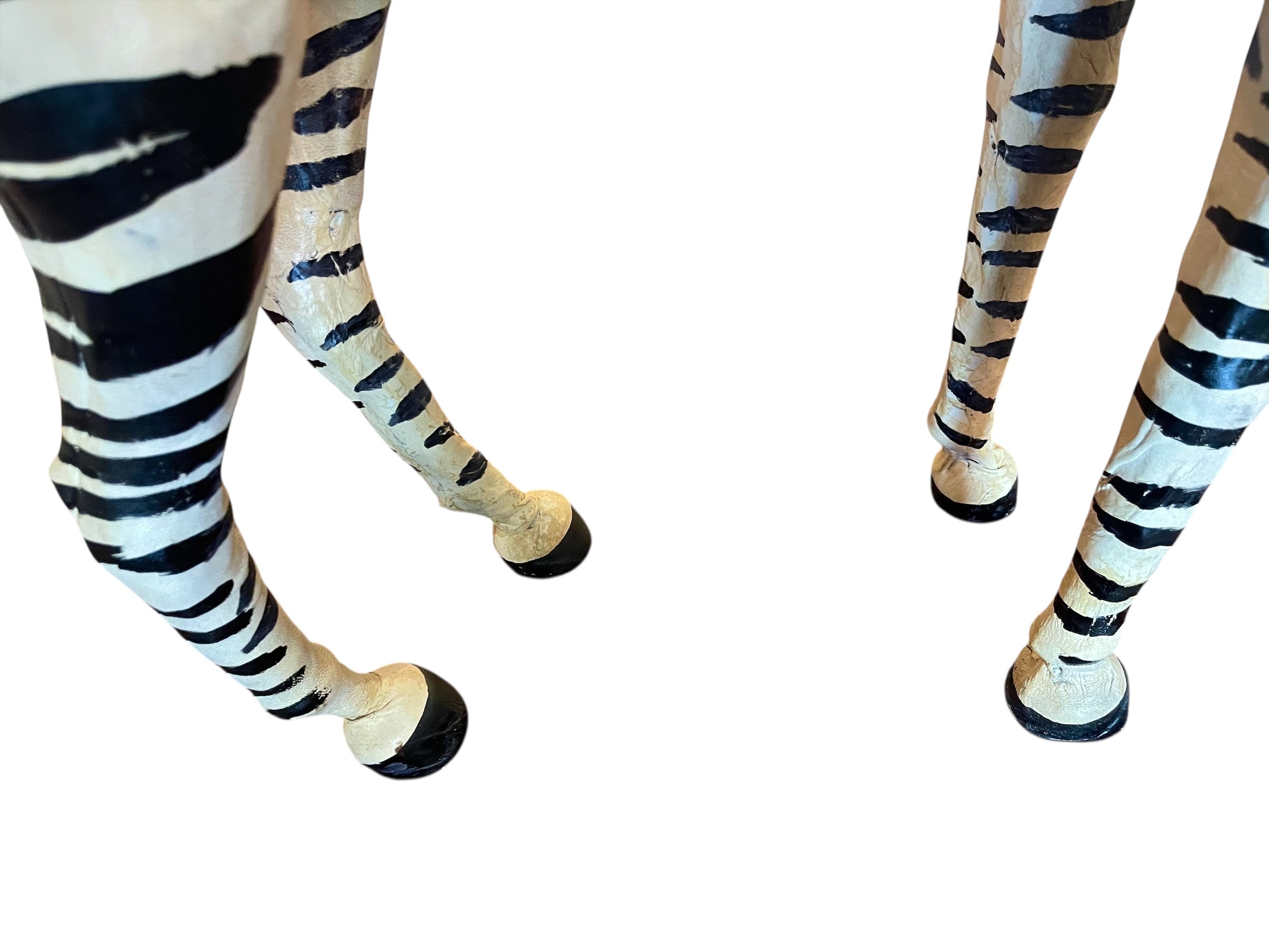 A full-length view of a standing zebra sculpture made from hand-painted leather. The sculpture features bold black and white stripes and shows signs of age, including slight yellowing and a tear on its leg.
Vintage
Antique
Art
Figurine
Decorative
Animal
Wear
Tear
Cream
Standing
Detailed
Full-length
Close-up