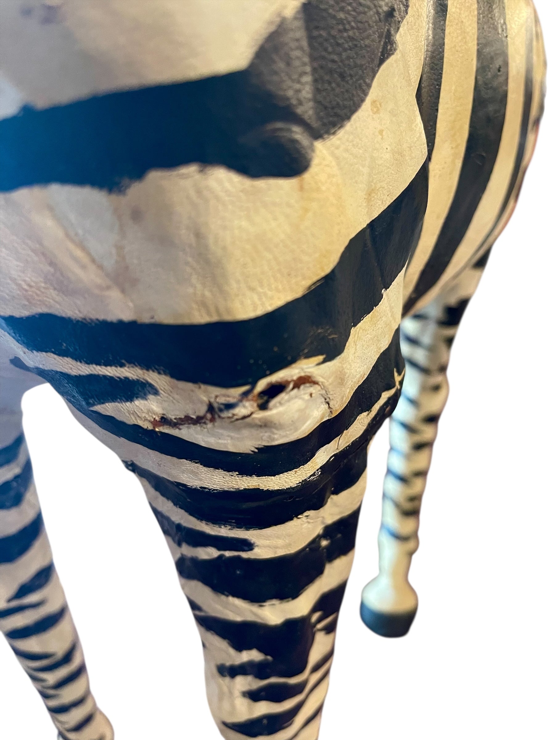 A full-length view of a standing zebra sculpture made from hand-painted leather. The sculpture features bold black and white stripes and shows signs of age, including slight yellowing and a tear on its leg.
Vintage
Antique
Art
Figurine
Decorative
Animal
Wear
Tear
Cream
Standing
Detailed
Full-length
Close-up