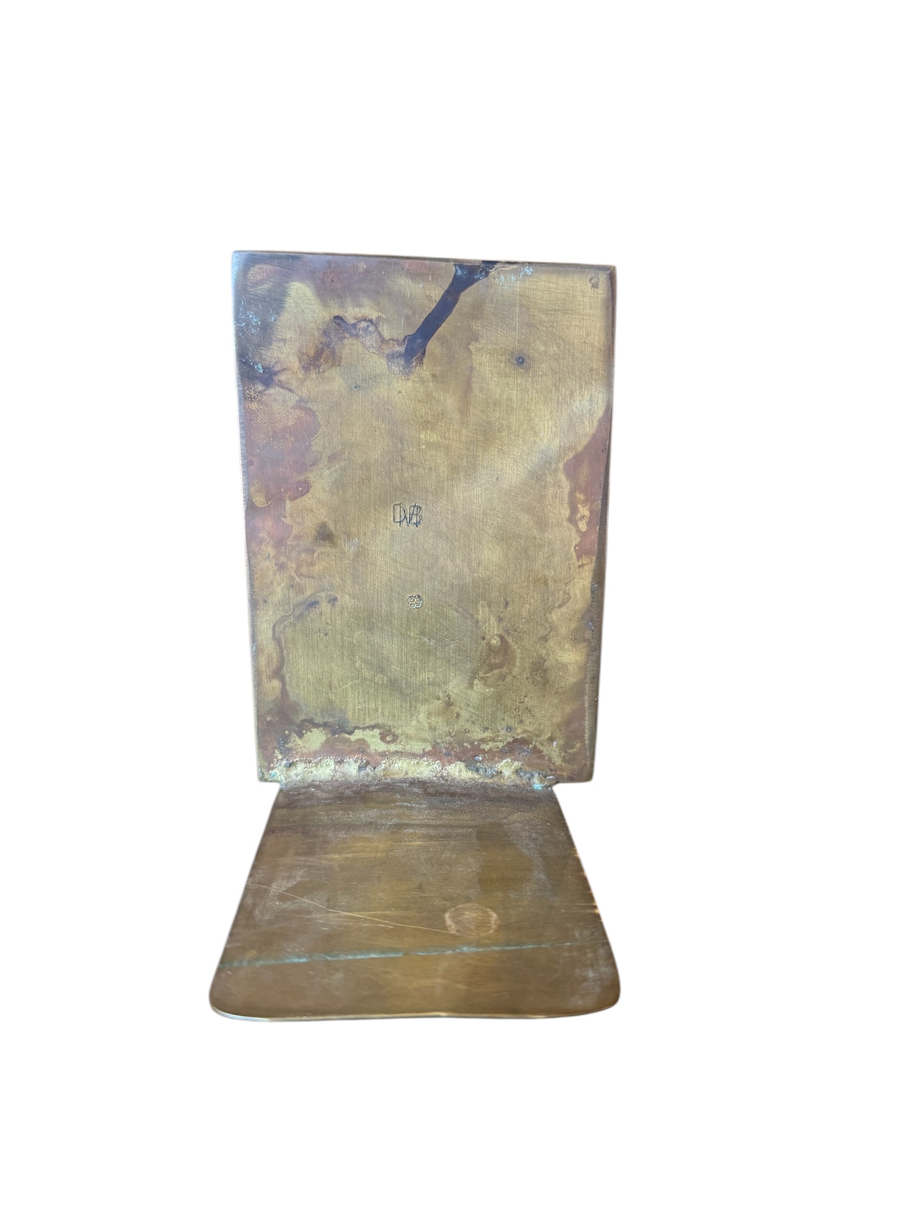 Close-up of two David Marshall Brutalist bookends. The bookends feature contrasting silver and bronze metal panels, separated by raised textured bronze seams. The bookends have a rough, geometric design.