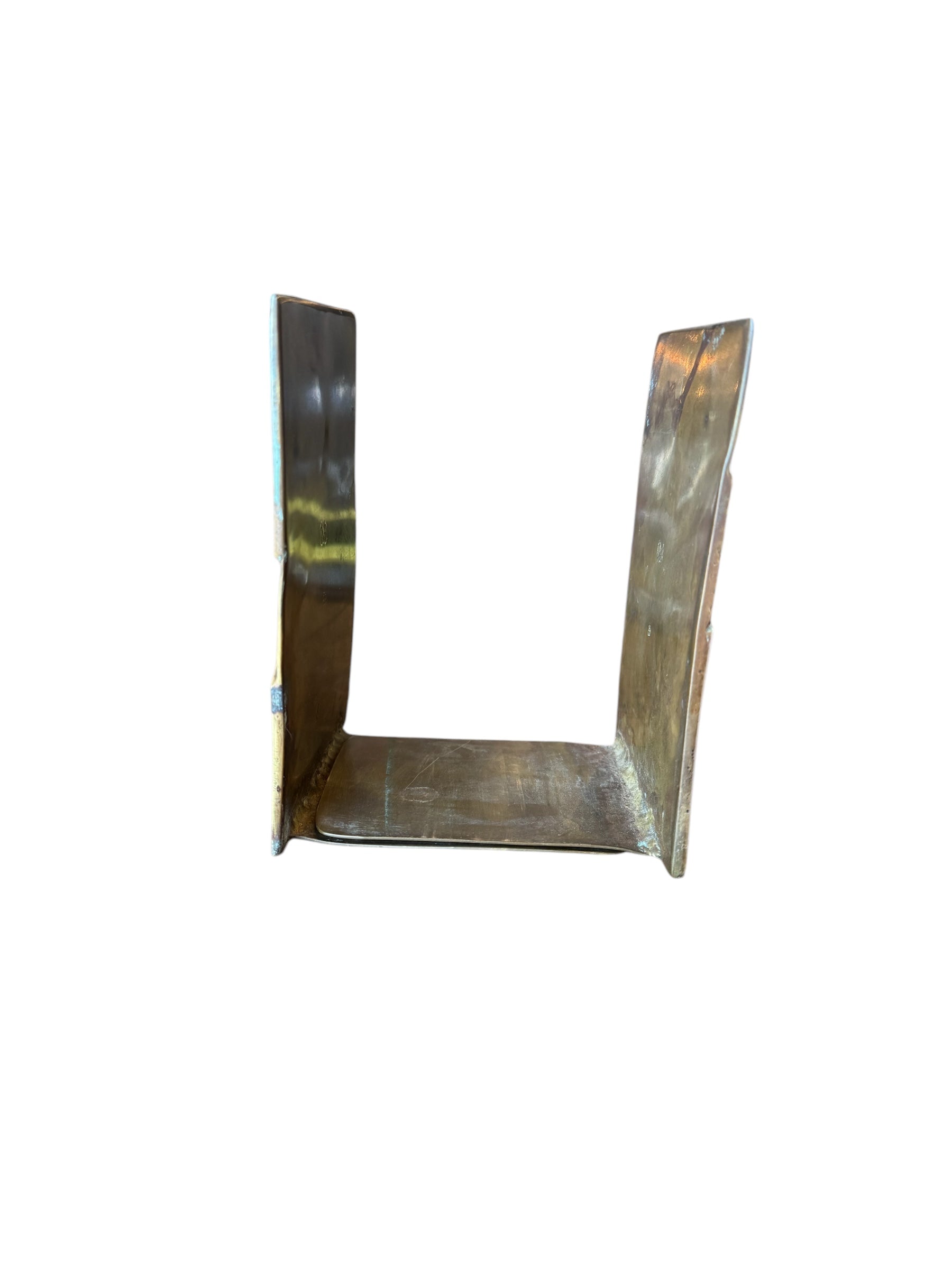 Close-up of two David Marshall Brutalist bookends. The bookends feature contrasting silver and bronze metal panels, separated by raised textured bronze seams. The bookends have a rough, geometric design.