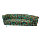 A Thayer Coggin rounded sofa with a Counterpart Studios multicolored floral pattern on the upholstery, featuring a vintage frame and metal legs.