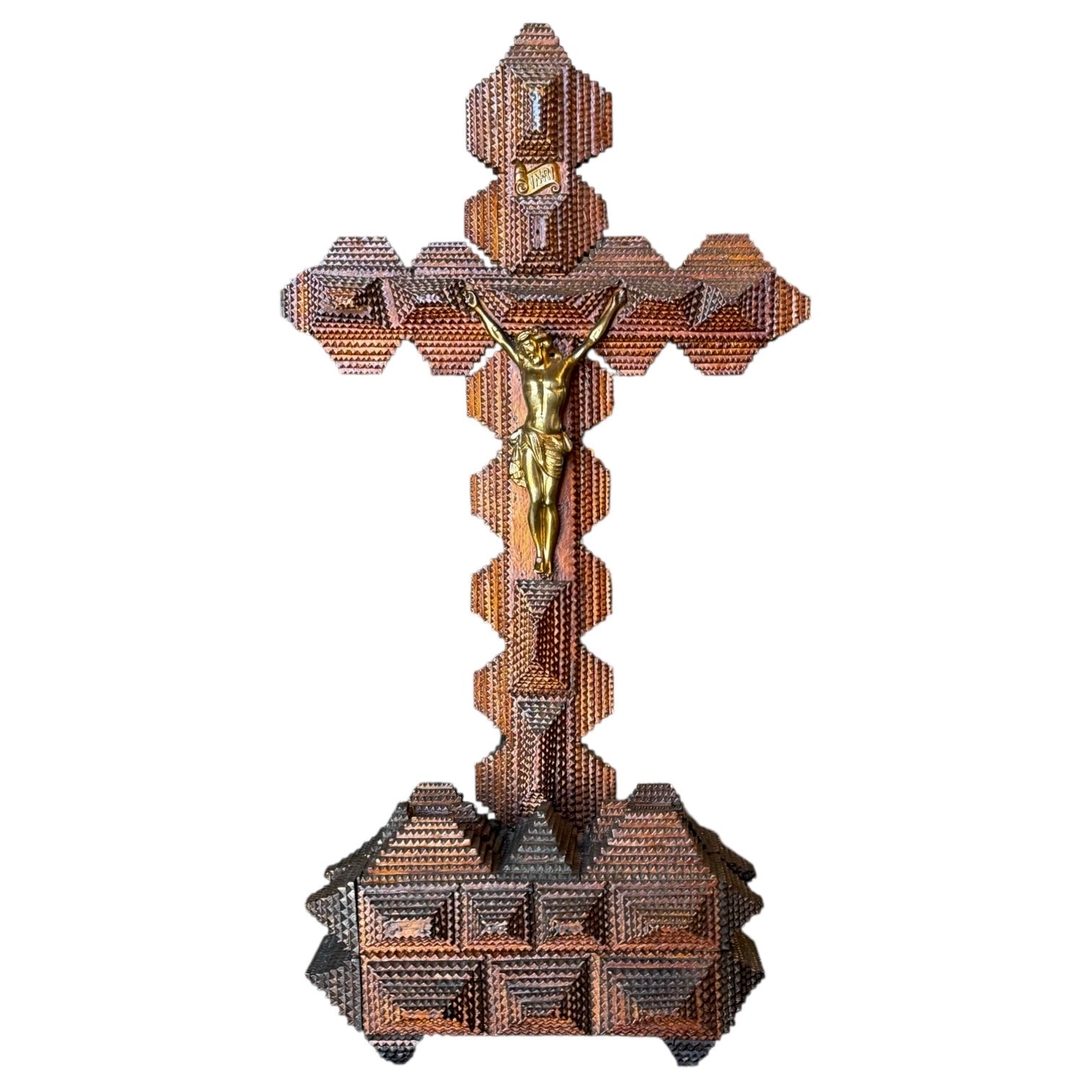 An intricate, hand-chipped carved tramp art crucifix with a gold-tone metal Corpus Christi, showcasing the crucifixion of Jesus Christ.