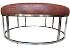 A large round ottoman with a croc-embossed brown vinyl cushion and a silver chrome base by Mitchell Gold and Bob Williams.