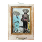 A hard-tinted photograph of two young boys in cowboy regalia, with ropes and boots, housed in a window style frame.