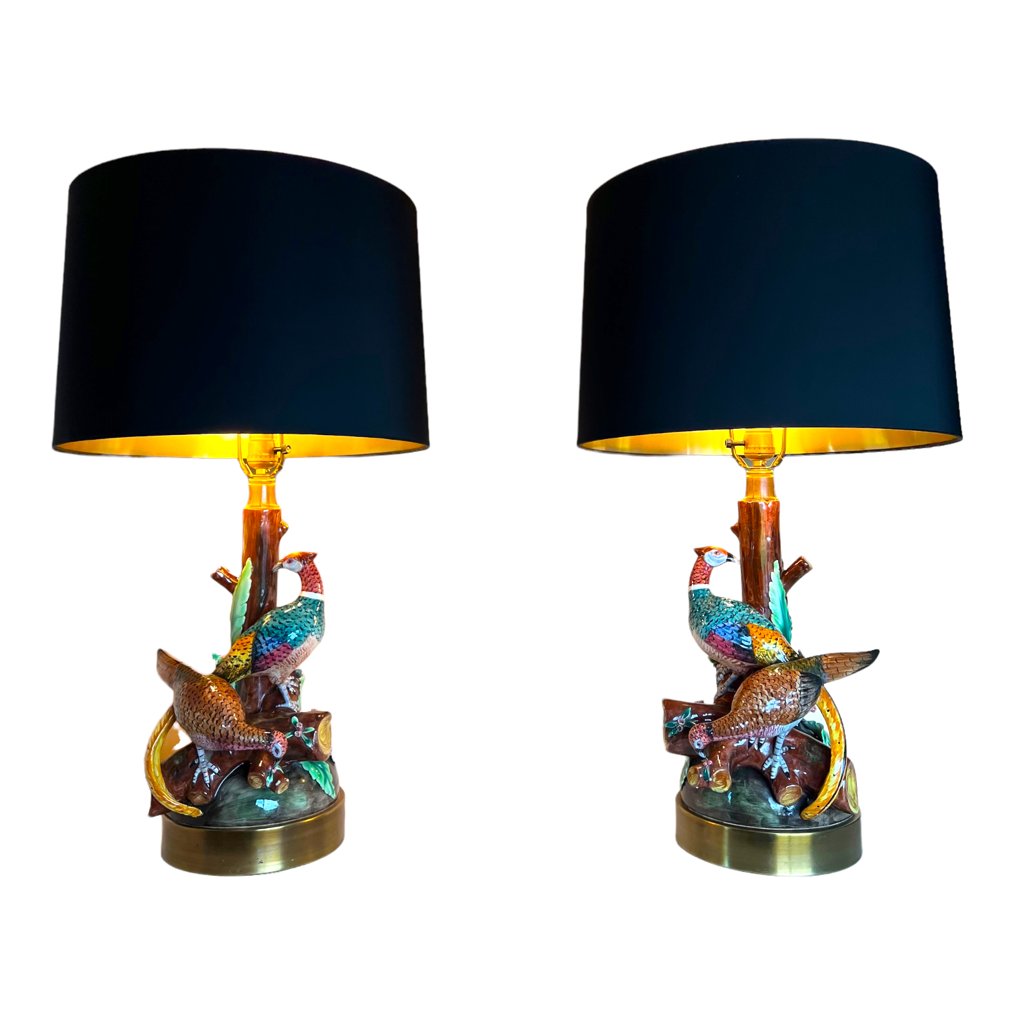 A pair of large, hand-painted French majolica table lamps with pheasant designs on a tree branch motif, featuring black and gold lamp shades.
Majolica pheasant table lamp pair
