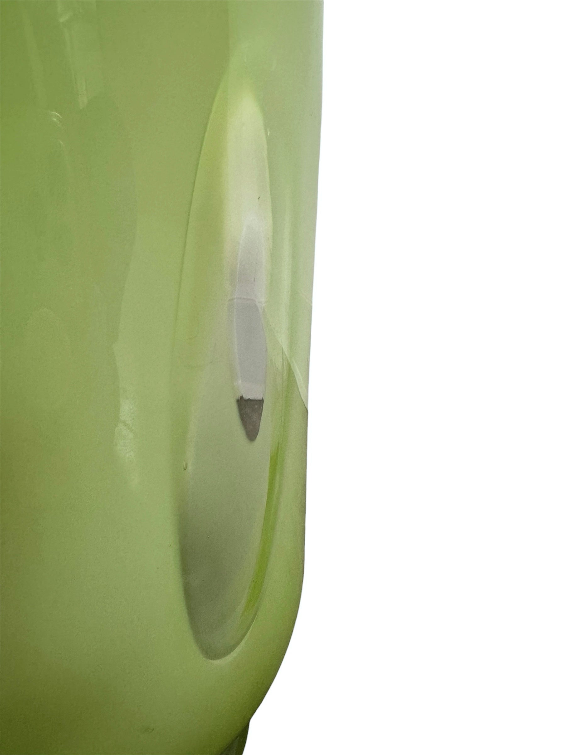 A mid-century modern, lime green cased-glass vase with a wide, flared rim and a thick, clear glass base. The exterior is a glossy chartreuse green, while the interior is lined with solid milk-white glass. The defining feature is a large, vertical oval cutout window that pierces directly through the center of the vase's body, creating an open-air negative space.