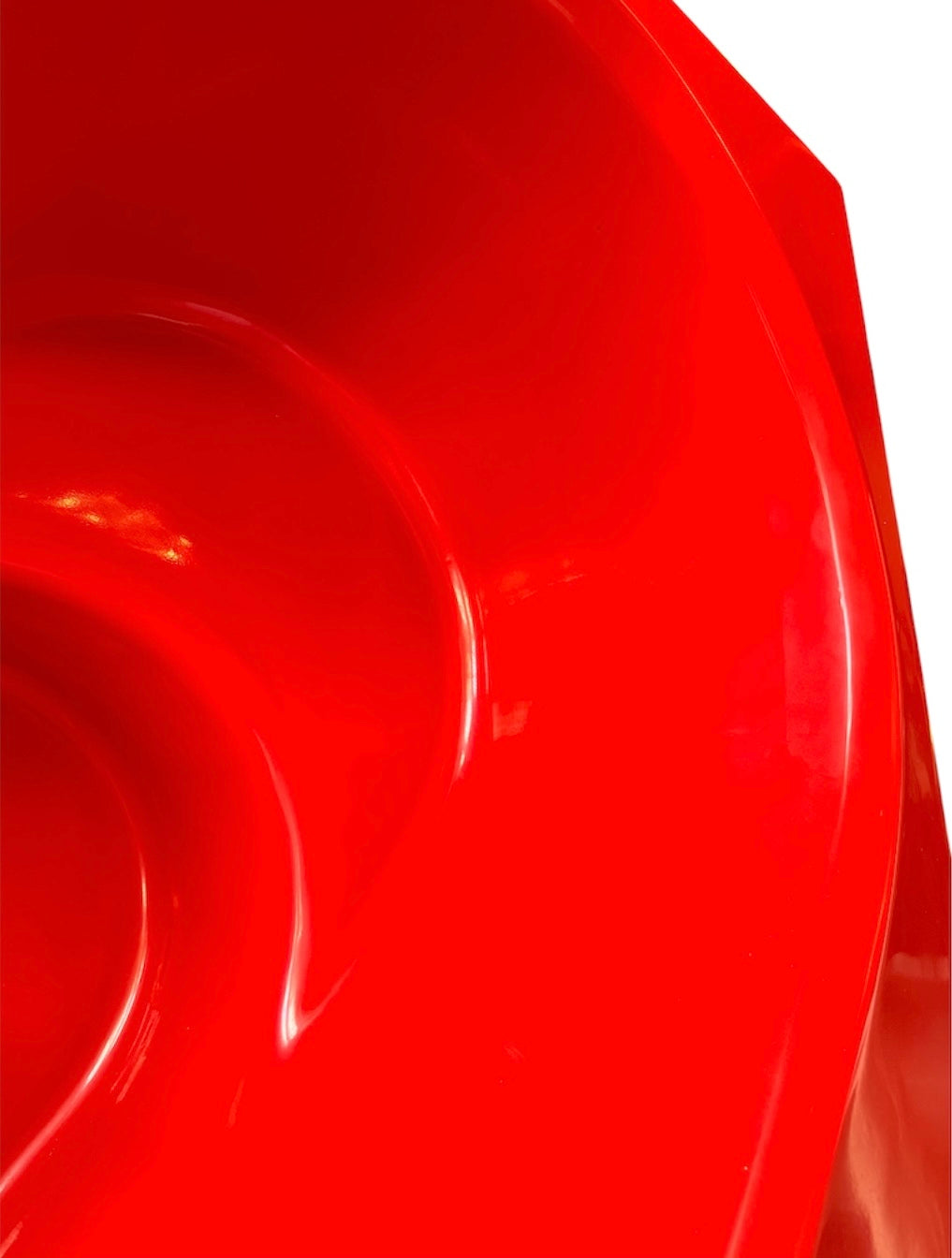 A top-down, straight-on view of a vintage, high-gloss cherry red bathtub. The tub basin is molded into a distinct double-tiered heart shape, with a shallower outer heart cascading into a deeper, smaller inner heart basin centered within a wide rectangular red deck.