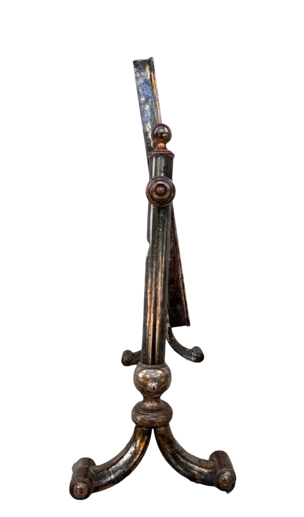 The antique Chevalier Mirror features a rectangular swing frame supported by two turned posts on decorative trestle feet. The mirror stands on four scrolled feet and features its original tarnished, silvered finish. The front of the mirror reflects a bright blue sky with wispy white clouds. The original dark brown backing is still attached to the frame.