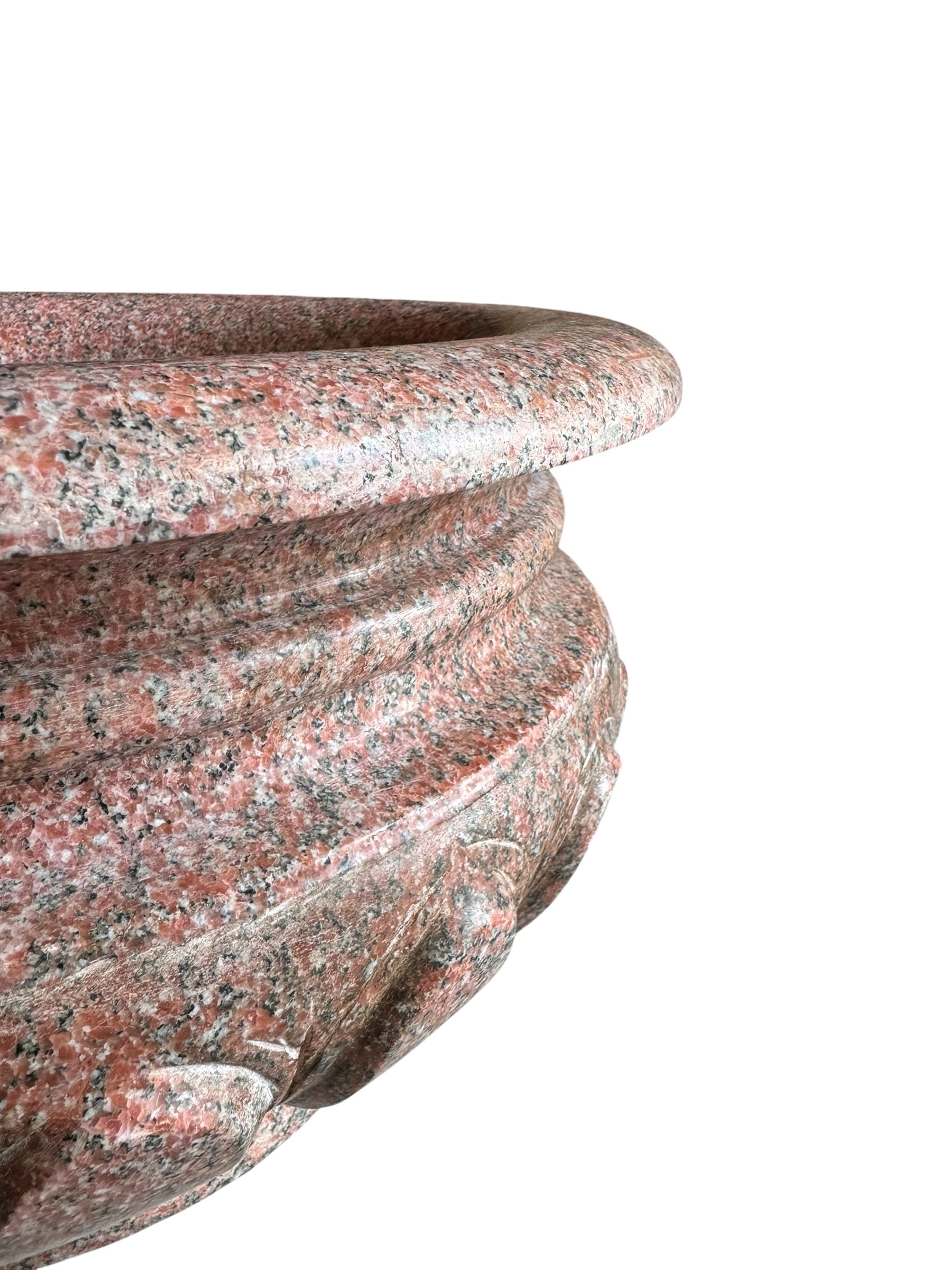 A carved pink granite planter with a leaf pattern, designed for indoor use without drainage.