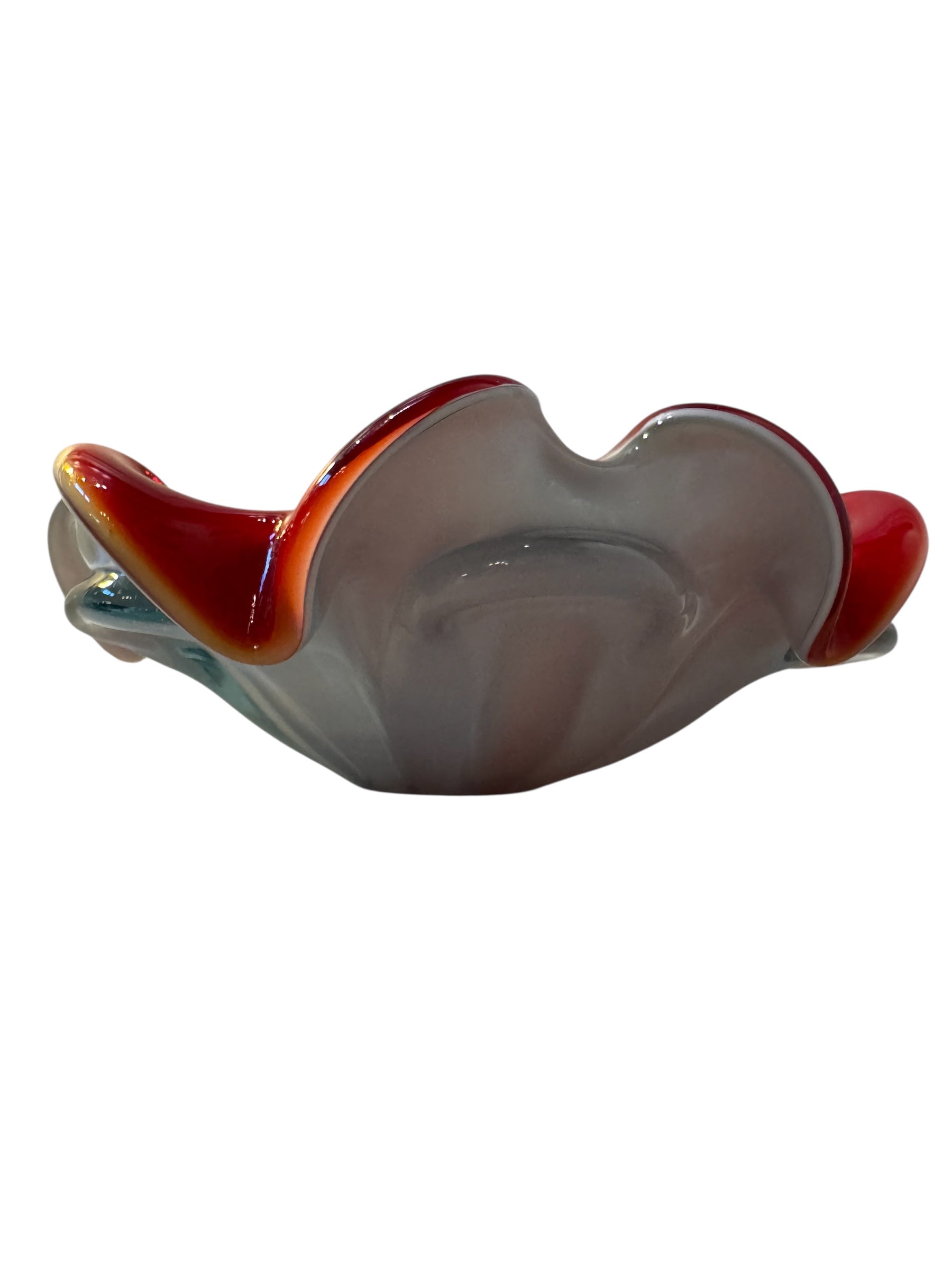 A Murano art glass bowl featuring a vibrant red interior encased in white glass, with a decorative ruffled edge. The piece is handblown, showcasing the Incamiciato technique.