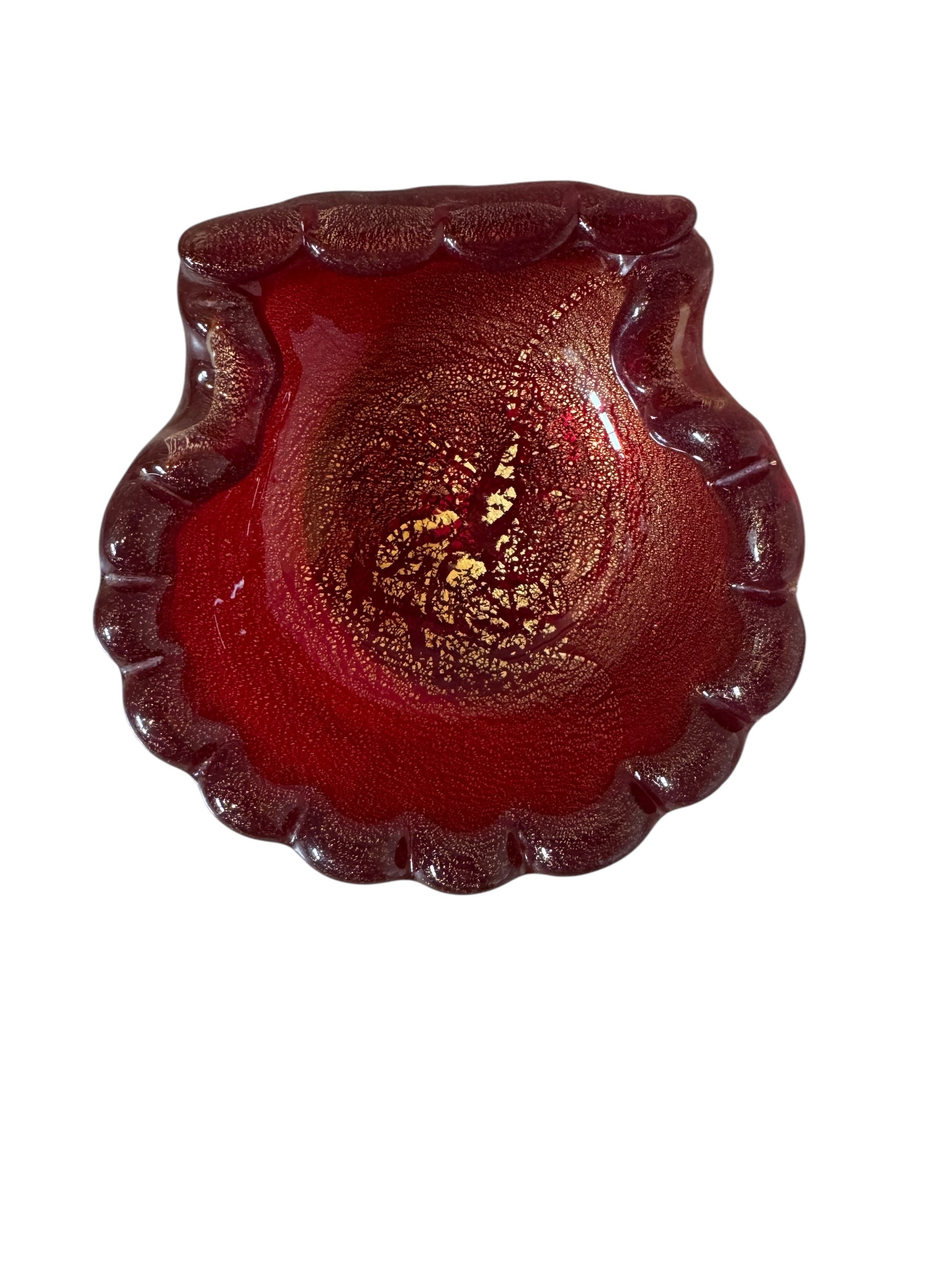 A handcrafted Murano glass bowl with a ruffled edge, deep red color, and gold specks created using the "oro zecchino" technique. The surface has a crackled gold pattern that reflects light, making it a striking decorative piece.