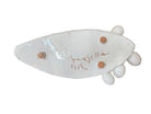A white, glazed ceramic platter in the shape of a prickly pear cactus pad with attached prickly pear fruit. The surface has raised dots representing spines. 