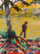 A vibrantly colored landscape painting titled 'Perdernales Falls Fisherman,' featuring two large trees with prominent exposed roots framing a body of water. A lone figure, a fisherman, stands by the water in the middle ground. The painting uses bold strokes of yellow, green, red, and blue, and is enclosed in a rustic dark wooden frame with a light-colored inner mat.