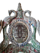 A pair of antique, heavily carved Anglo-Indian style throne chairs featuring lion figures as legs and arm supports, and peacock motifs on the backrests. The chairs have a distressed, multi-colored painted finish.