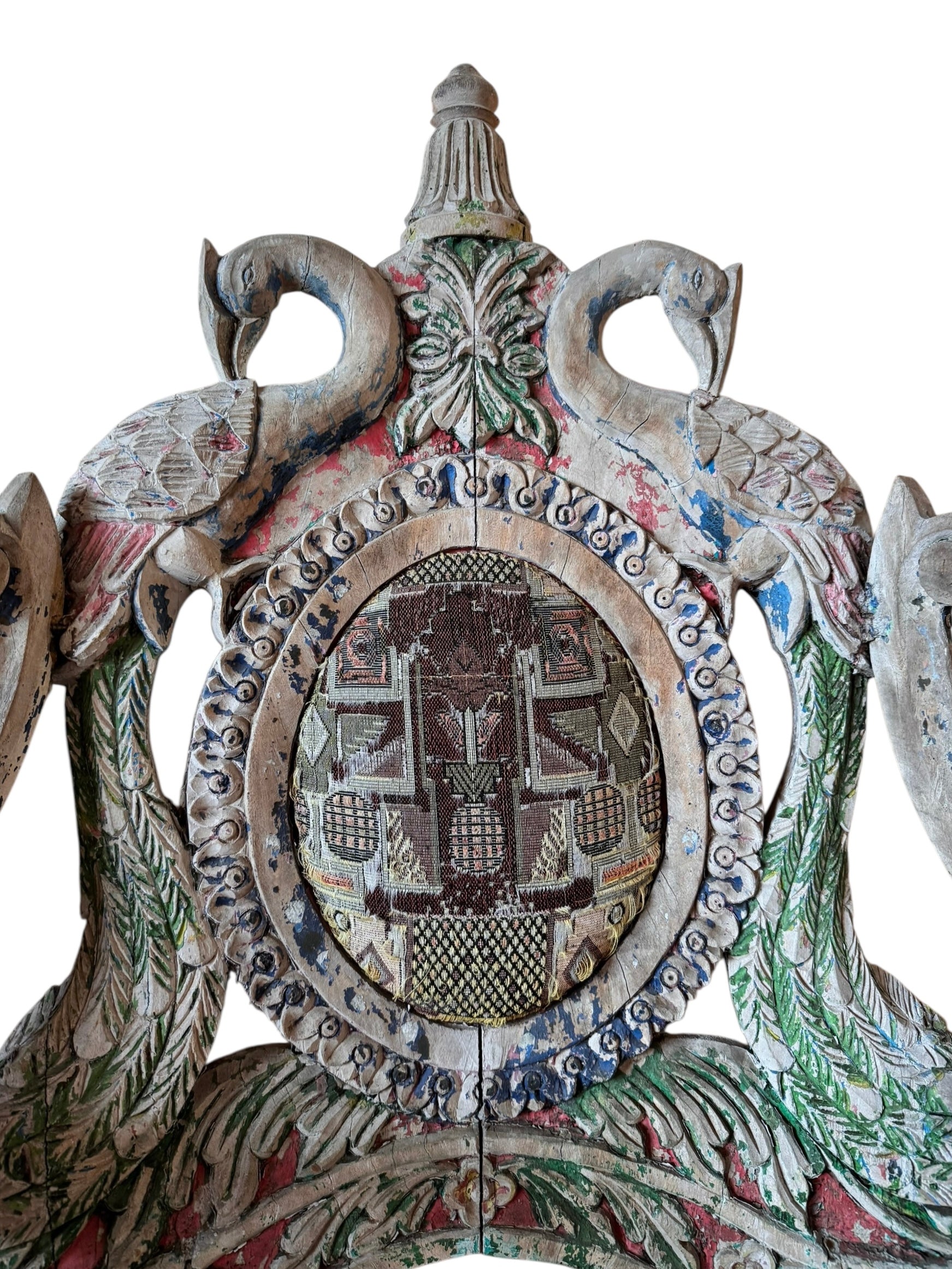 A pair of antique, heavily carved Anglo-Indian style throne chairs featuring lion figures as legs and arm supports, and peacock motifs on the backrests. The chairs have a distressed, multi-colored painted finish.