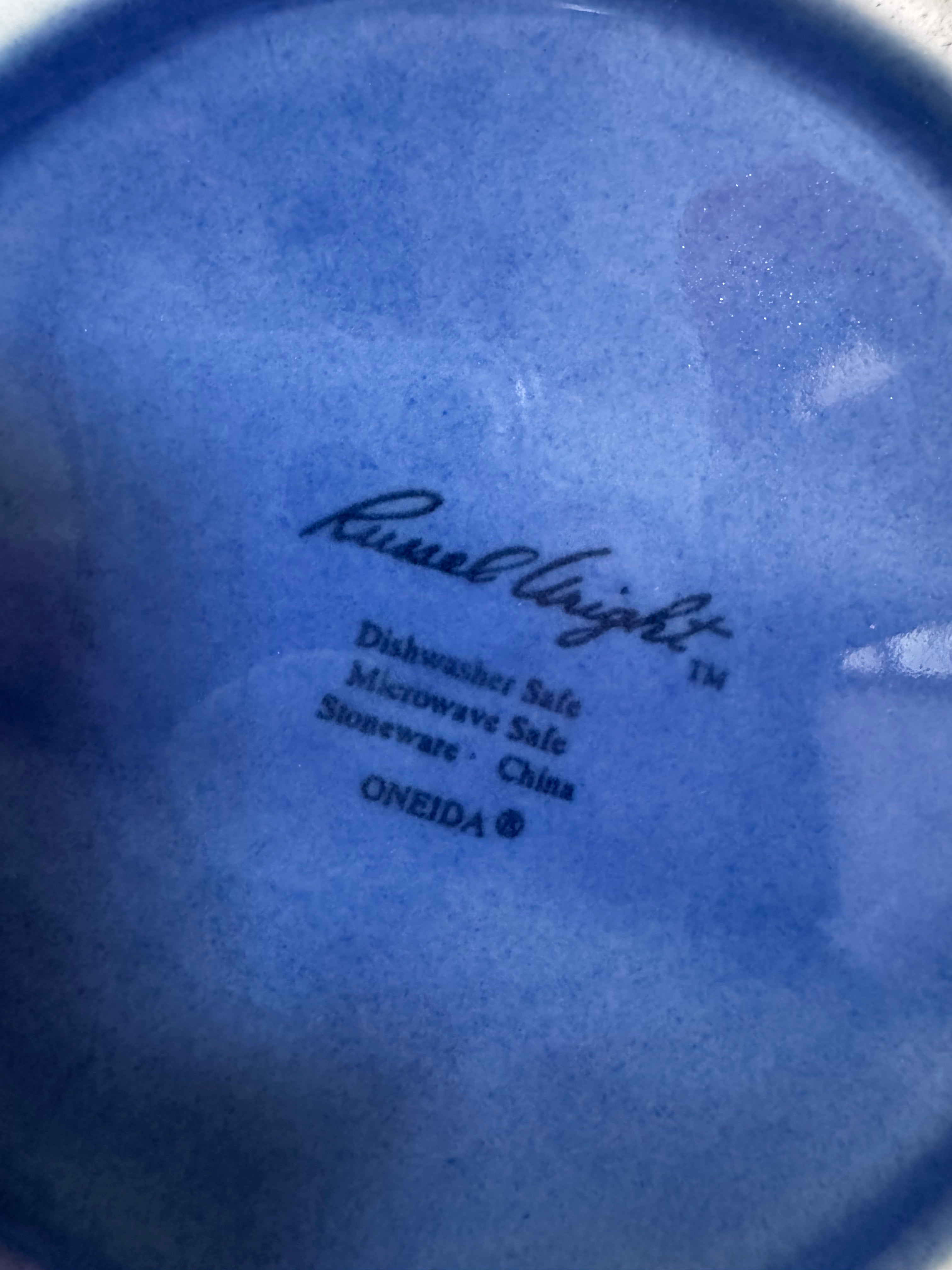 A Russel Wright American Modern stoneware water pitcher in a glossy Manitoga blue glaze is centered against a white background. The pitcher has a teardrop shape, a large handle, and a wide spout